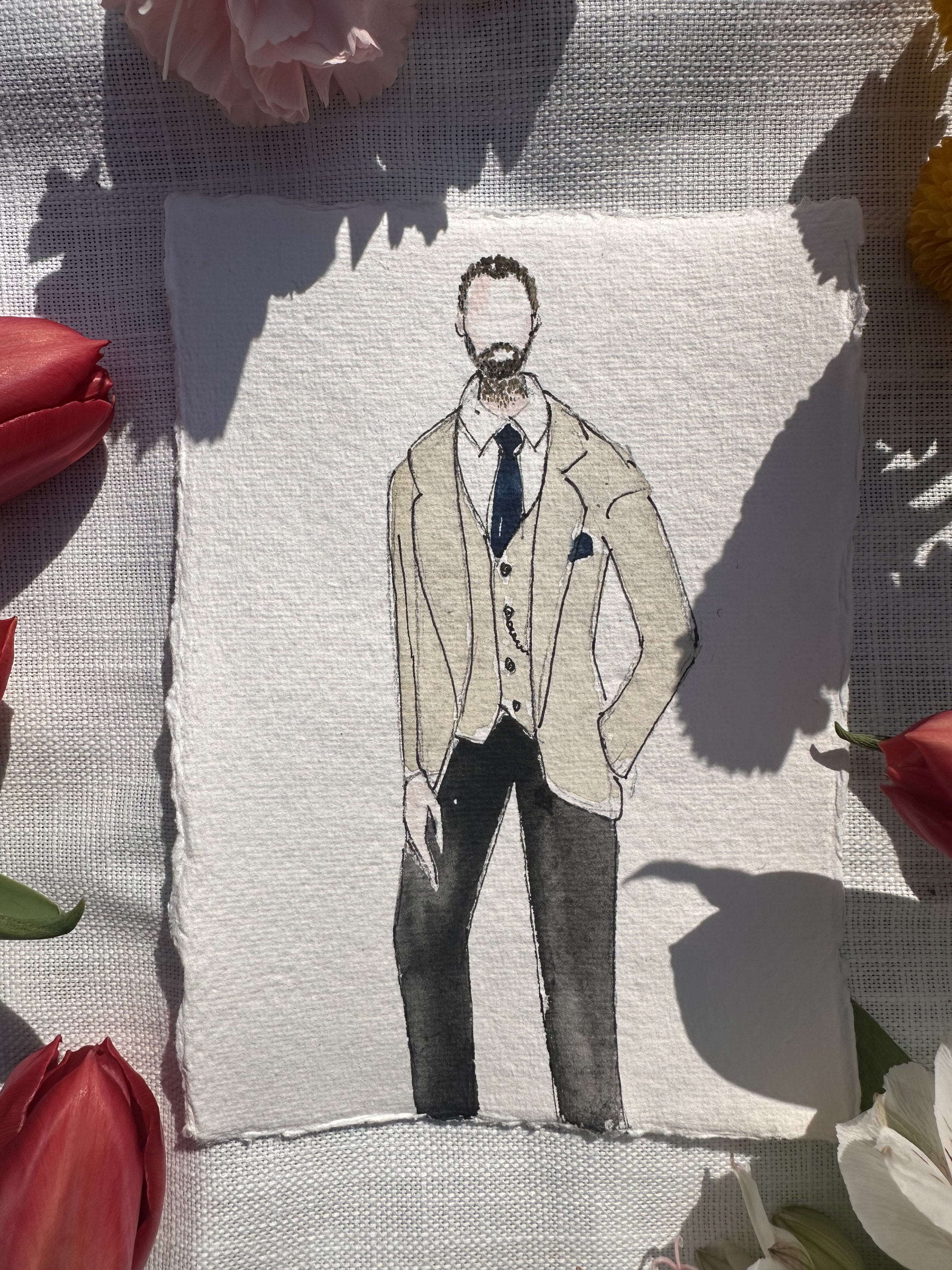A watercolor sketch of a man in formal attire, wearing a beige blazer, white shirt, and black trousers, with a dark tie and pocket square, standing with one hand in his pocket on textured paper surrounded by flowers.