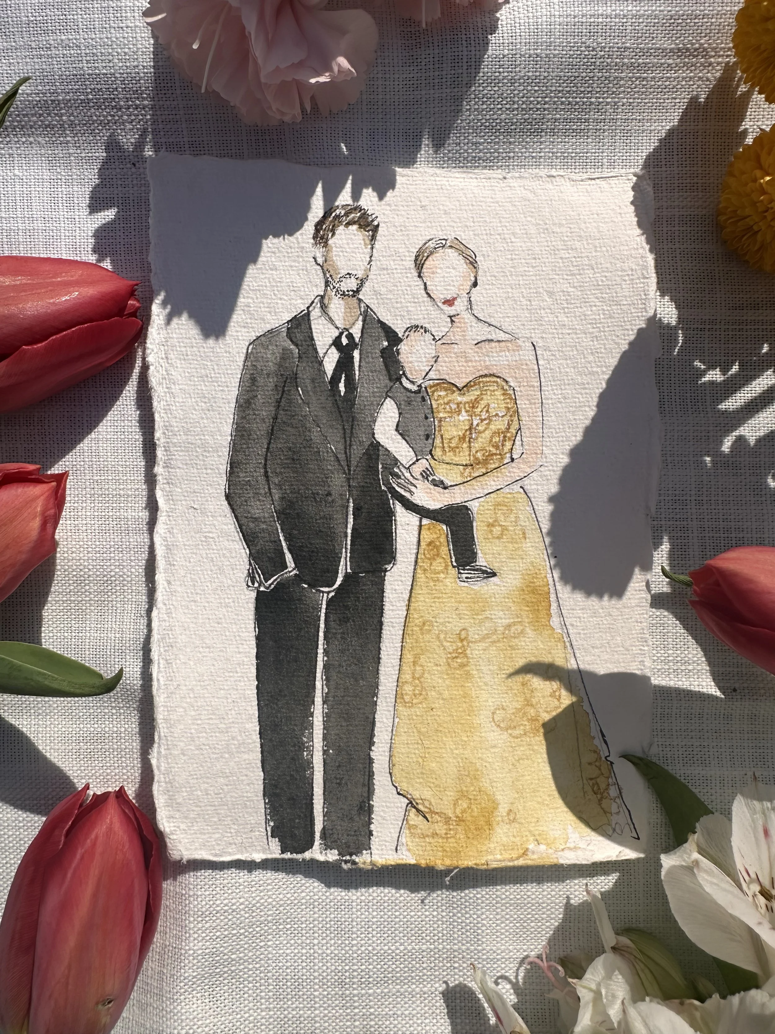 Watercolor illustration of a couple at their wedding, with the groom in a black tuxedo and the bride in a yellow gown, holding a young child.
