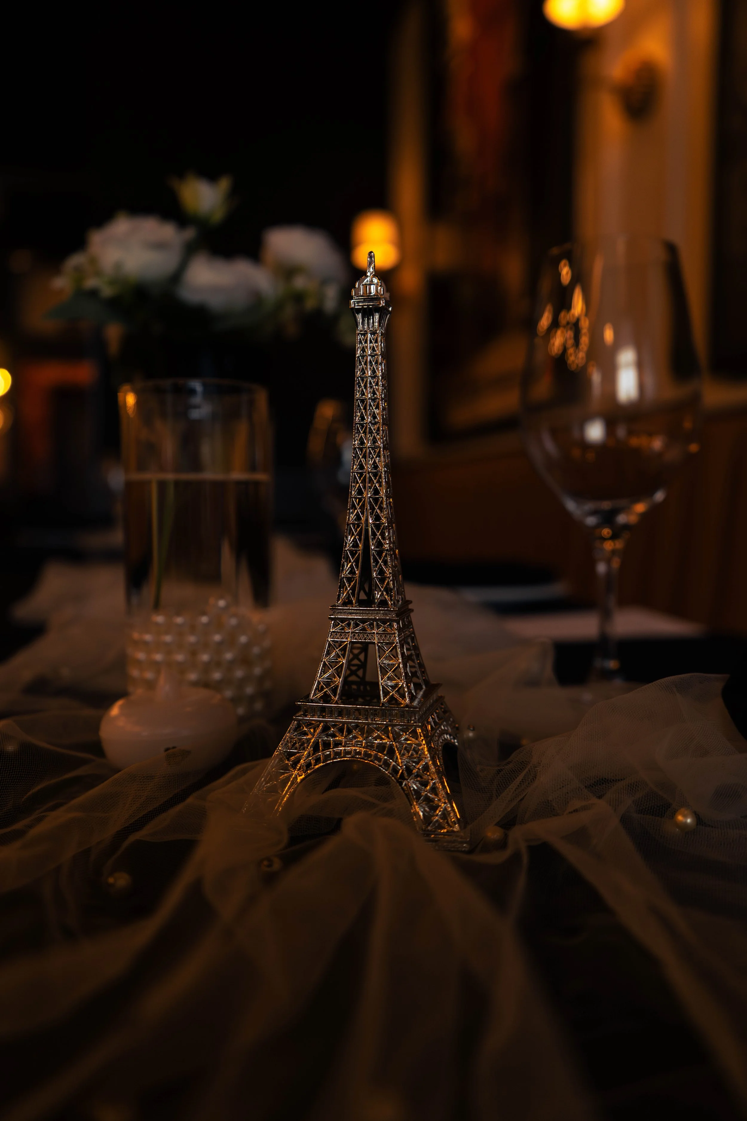 Elegant table centerpiece with Eiffel Tower decoration and soft candlelight — event detail photo by DRiccardi Photography, New York.