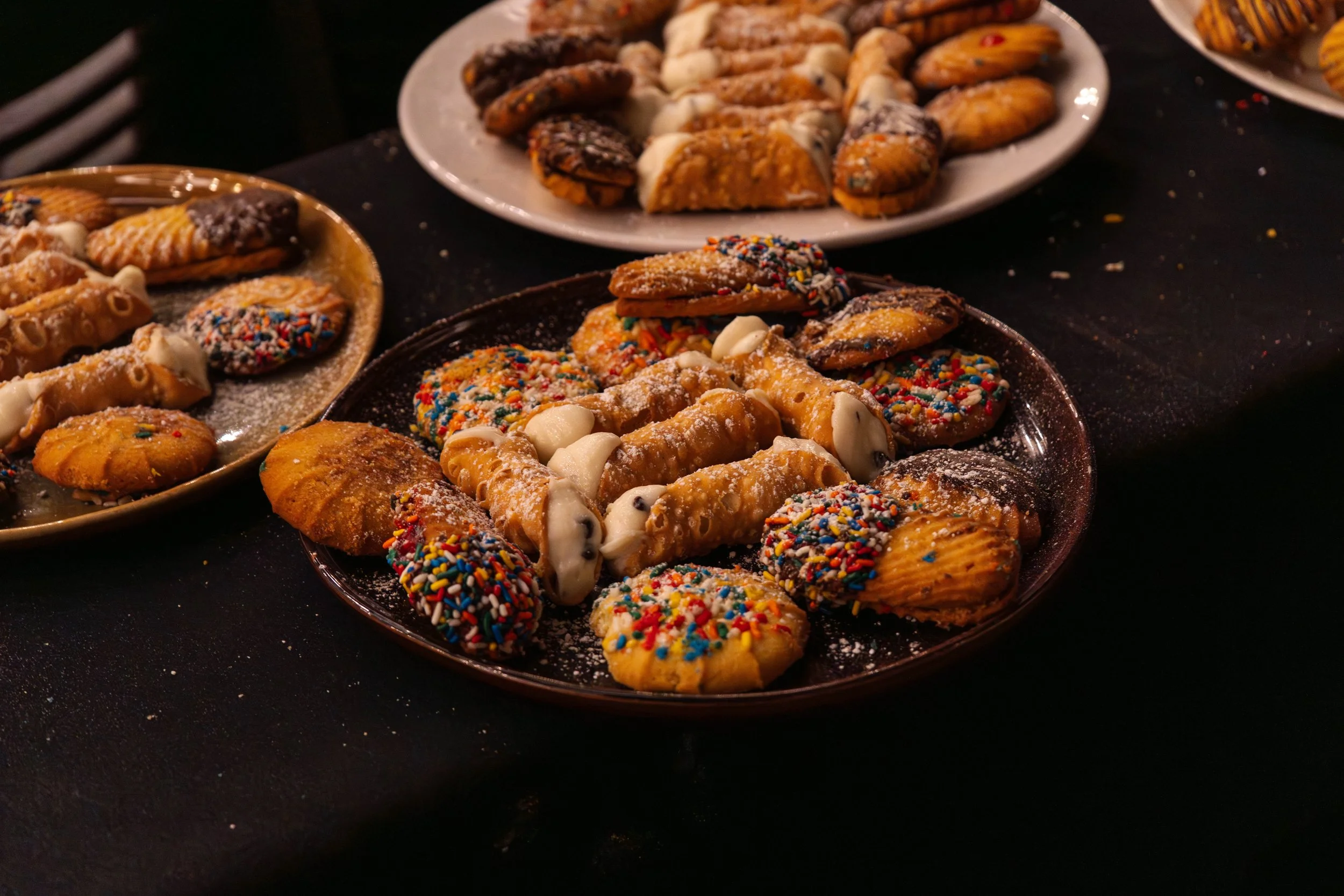 Plates of cookies, cannoli, and pastries on dessert table — event detail food photography by DRiccardi Photography, Long Island NY.