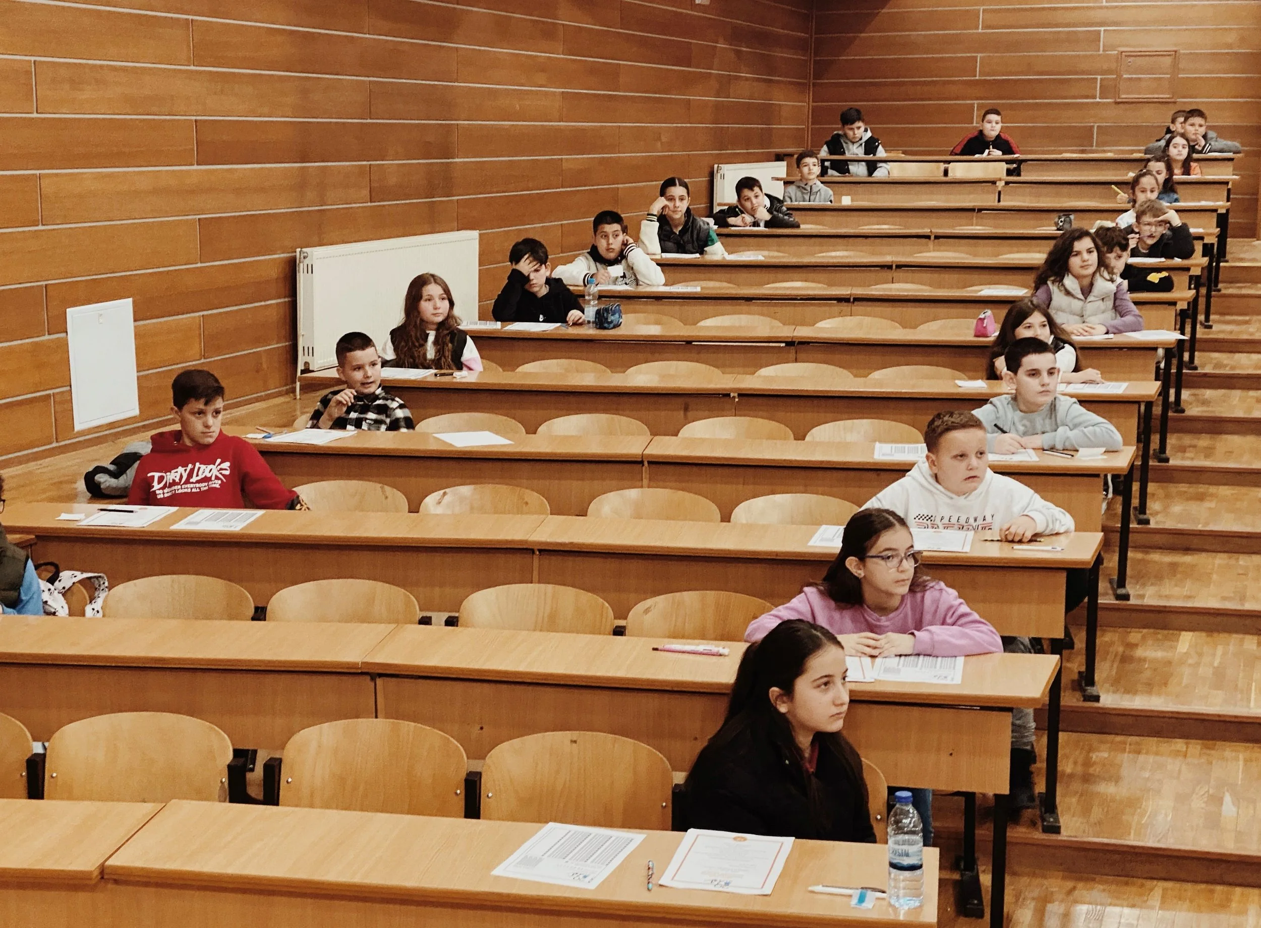 students spread out in a lecture hall ready to take an exam