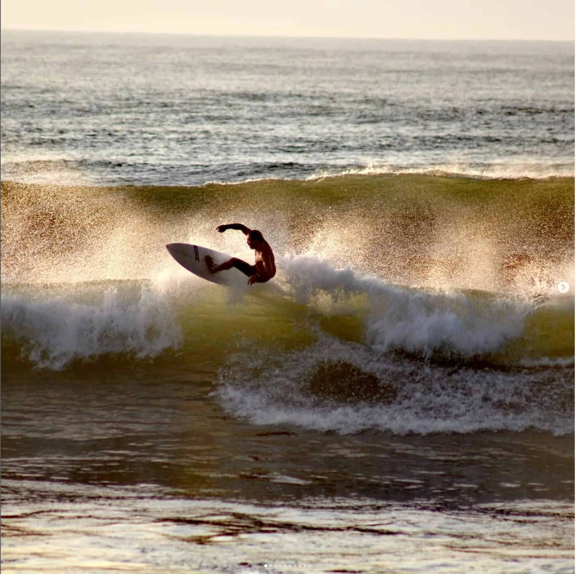 surfer in the waves at  Guanico Beach Resort