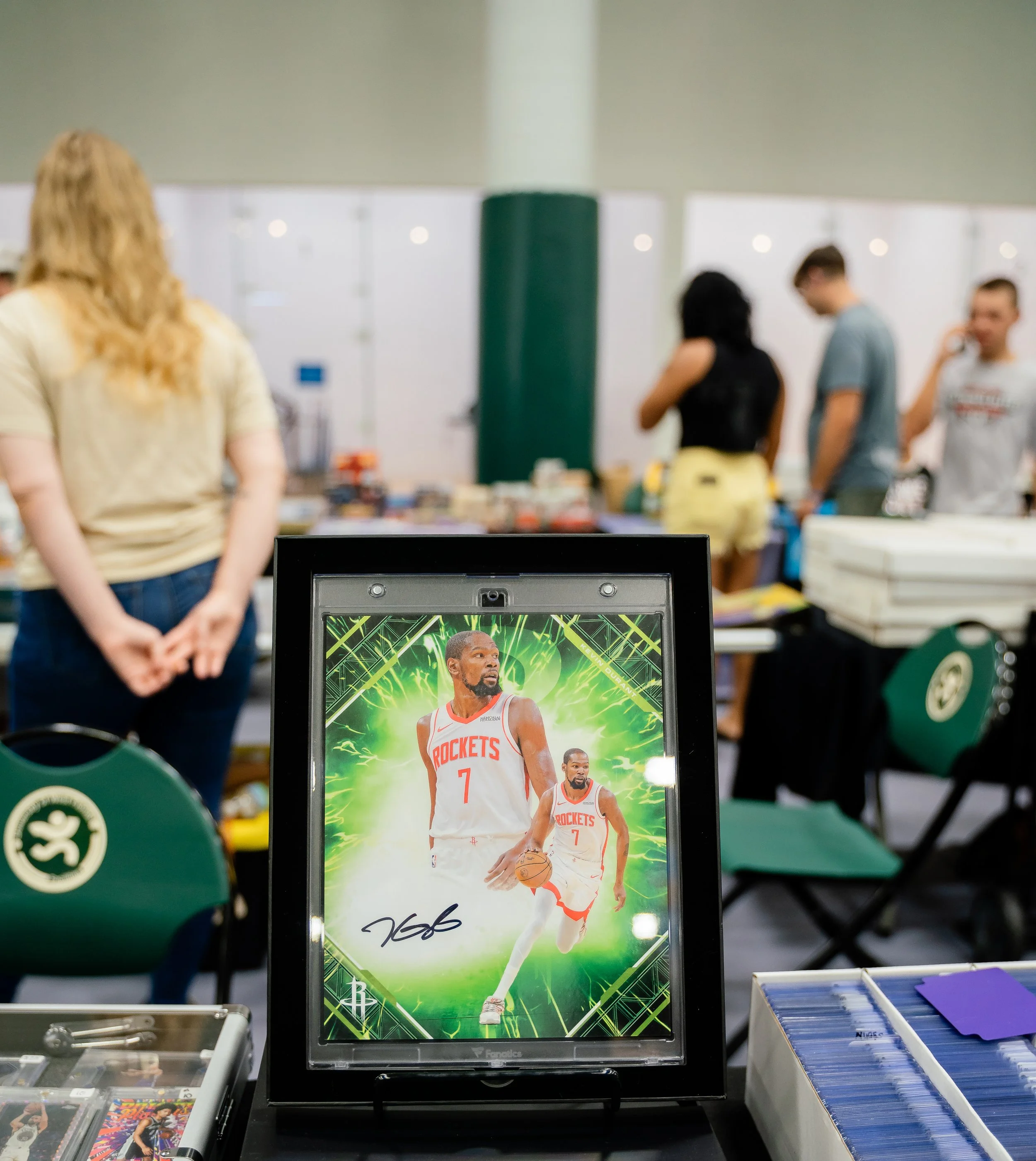 Display of a signed basketball trading card of NBA player Kevin Durant in a Houston Rockets jersey, with a vibrant green background and signature at the bottom.