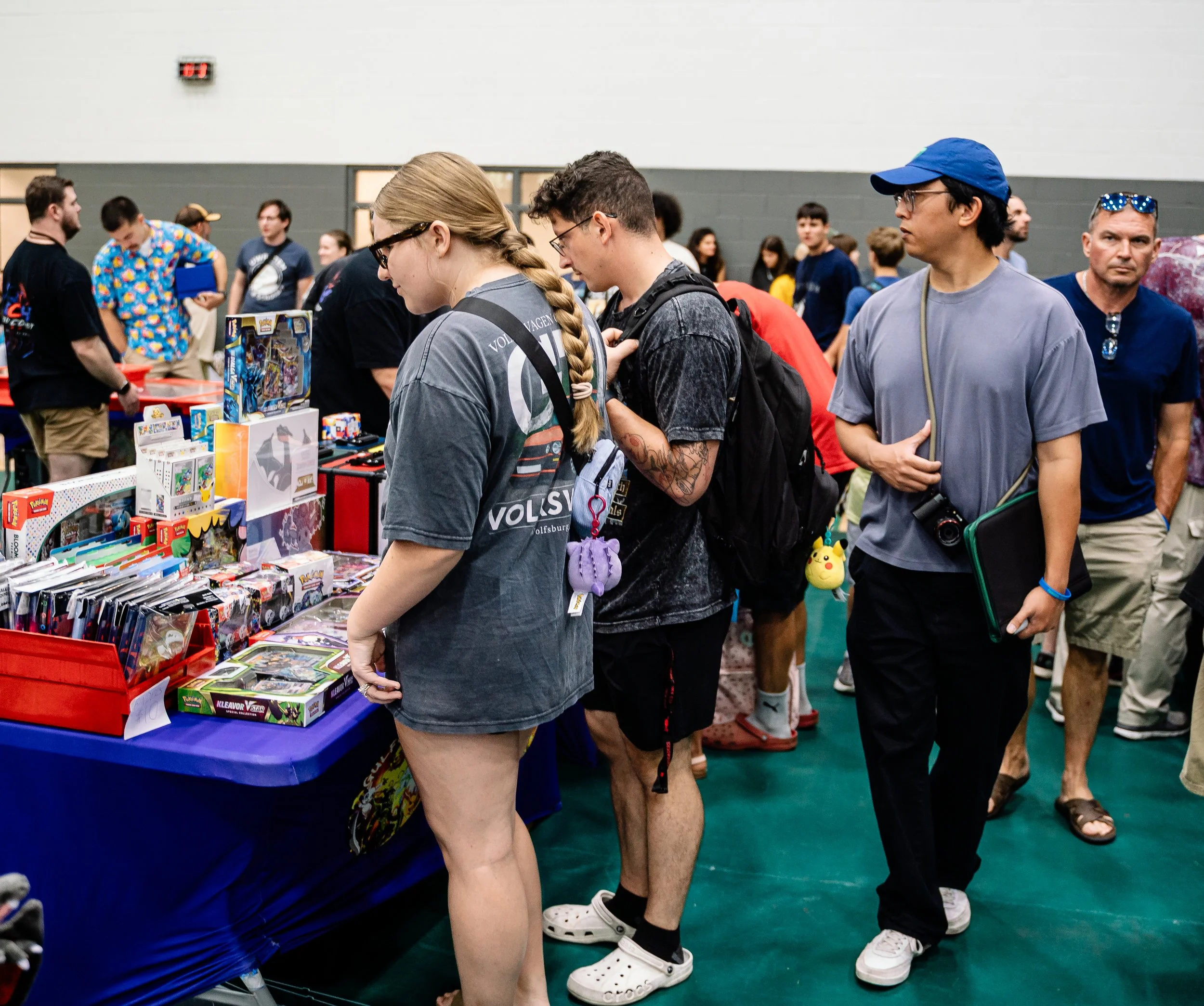 People browsing toys and games at a convention or event.