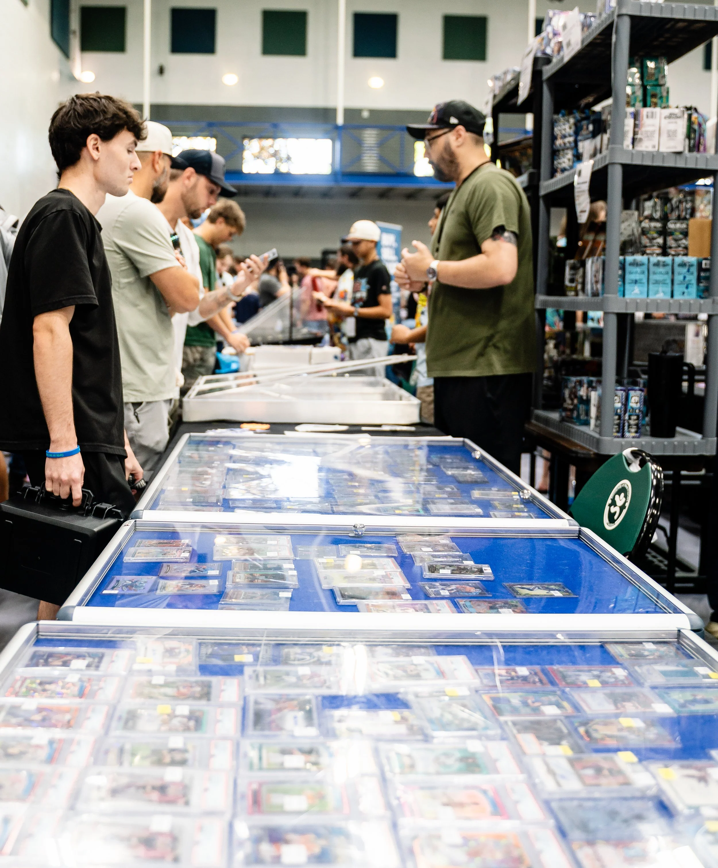 People are shopping for collectible trading cards at a retail store, browsing through display cases and shelves filled with collectible cards and related merchandise.