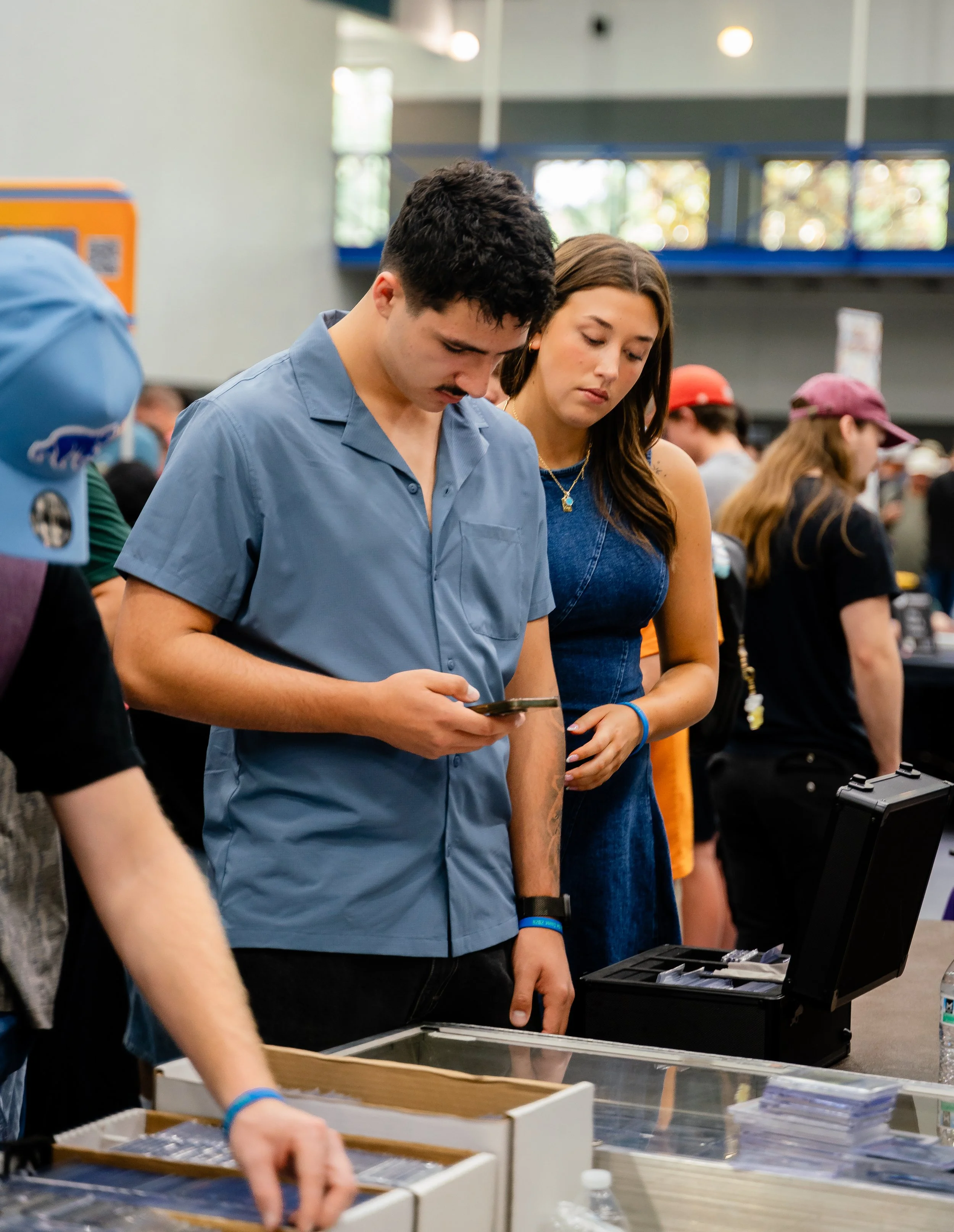 People browsing items at a tech or electronics event.