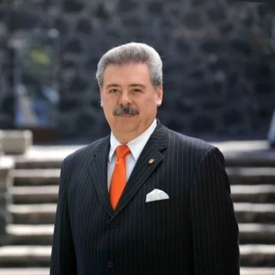 Black and white portrait of a man smiling in a collared shirt against a plain background.