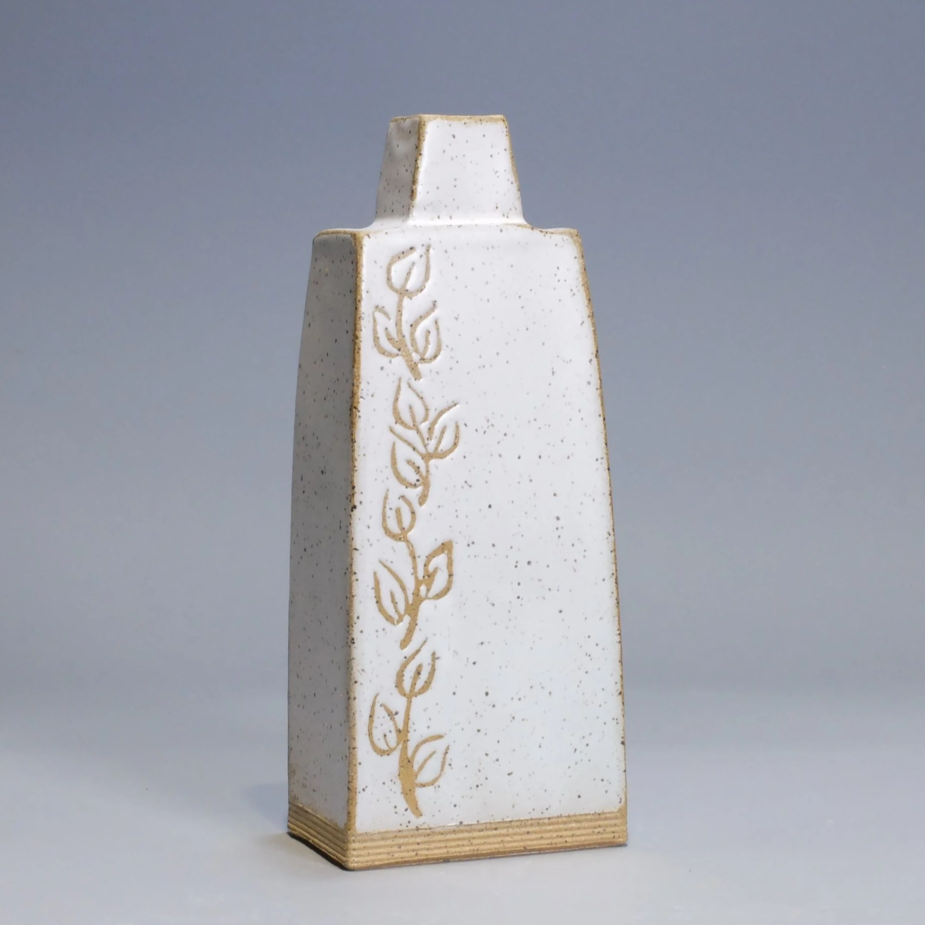 Bottle/Decanter, 2026. Speckled stoneware, white glaze, leaf & vine motif. 8.5"T, 3.5"W, 2.25"D