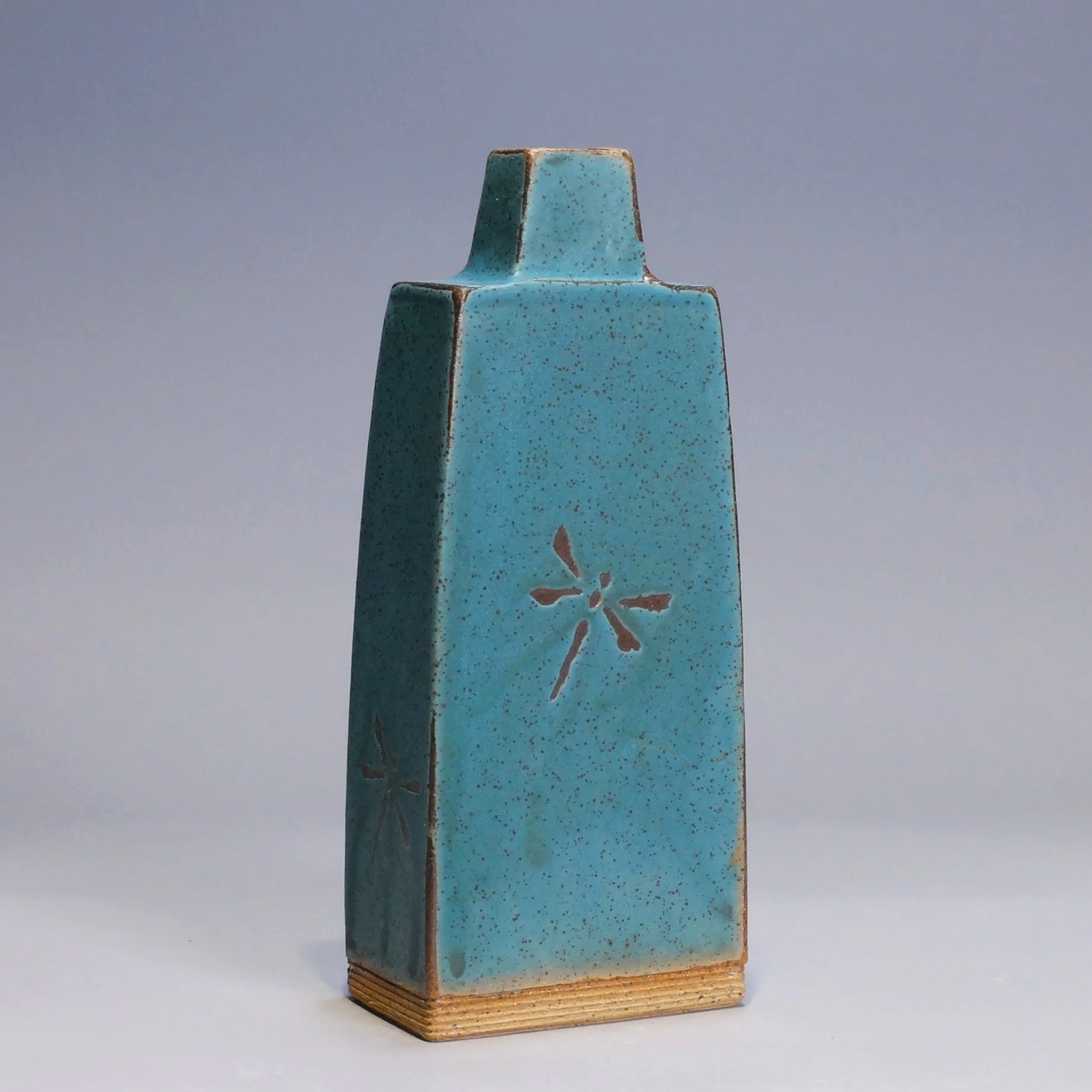 Bottle/Decanter, 2026. Speckled stoneware, turquoise matte glaze, dragonfly motif. 8.5"T, 3.5"W, 2.25"D