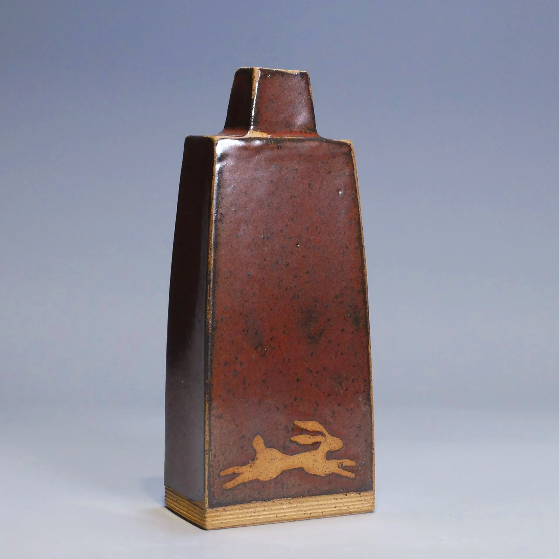 Bottle/Decanter, 2026. Speckled stoneware, red iron oxide glaze, dragonfly motif. 8.5"T, 3.5"W, 2.25"D