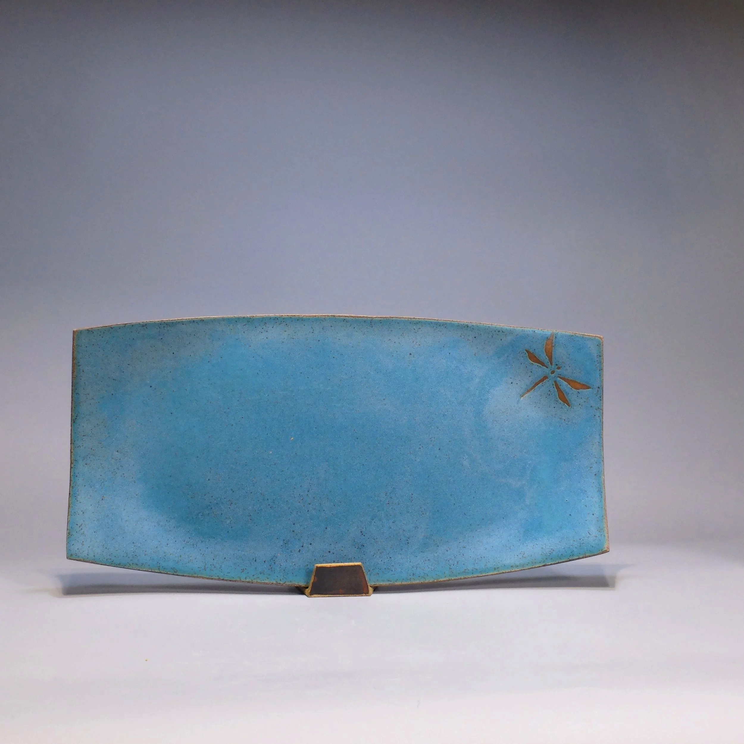 Platter, 2026. Speckled stoneware, turquoise glaze, dragonfly motif. 17.25"L, 8.75"W, 0.75"D.