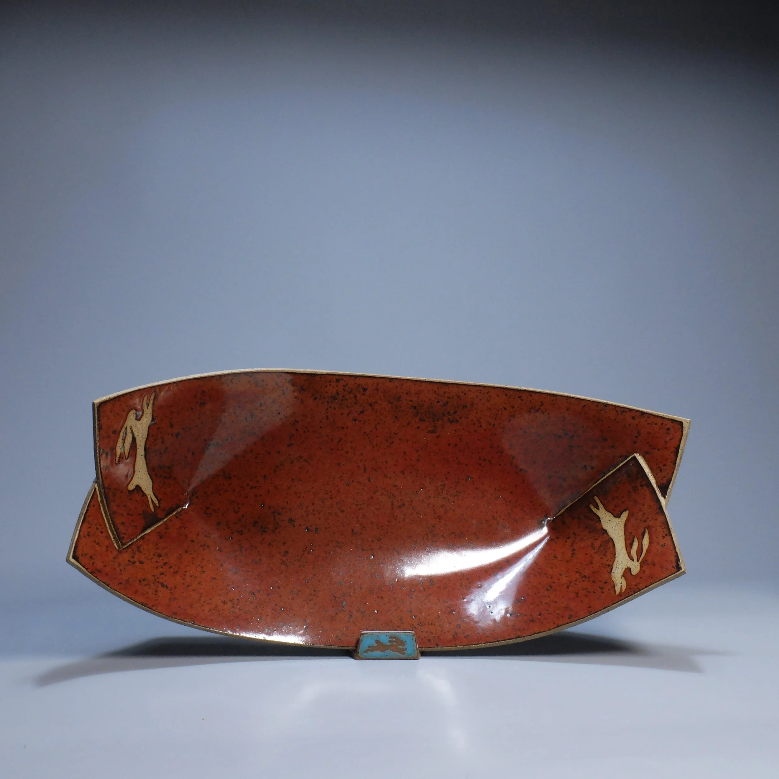 Big Boat, 2026. Speckled stoneware, red iron oxide glaze, leaping hare motif. 16.5"L, 8.5"W, 5.25"D.