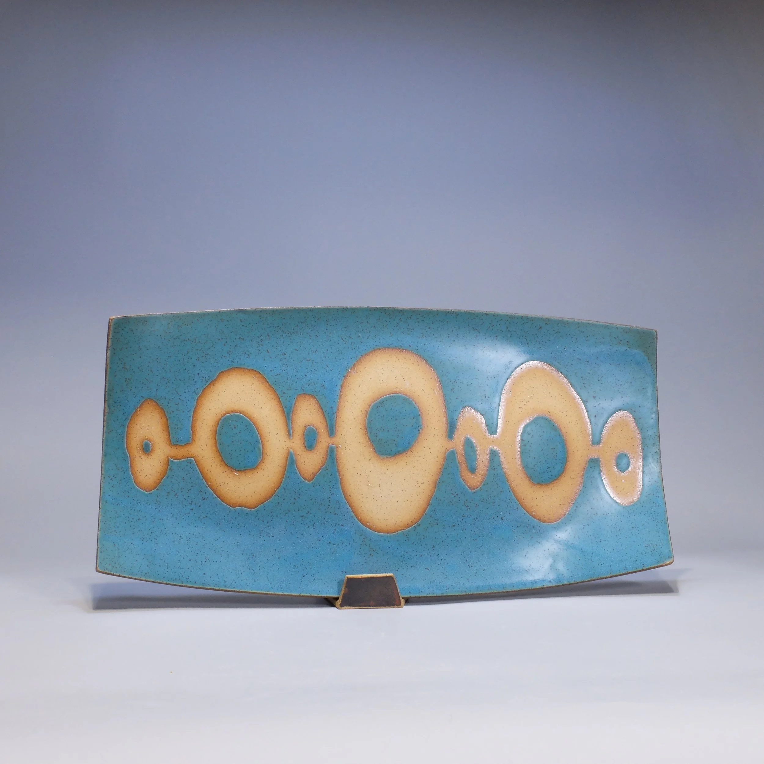 Platter, 2026. Speckled stoneware, turquoise glaze, geometric motif. 17.25"L, 8.75"W, 0.75"D.