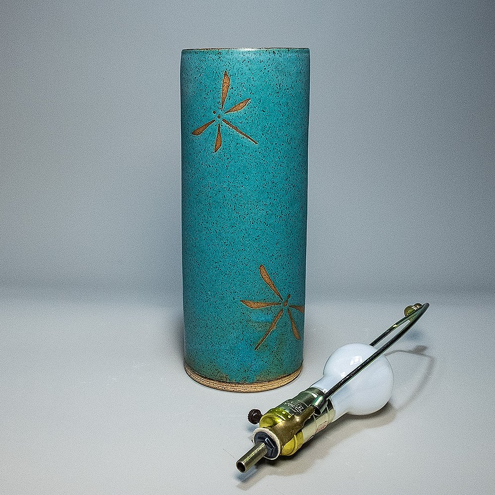 Cylinder Lamp Base 2026. Speckled stoneware, turquoise matte glaze, dragonfly motif. 12"H, 4.5"Dia.