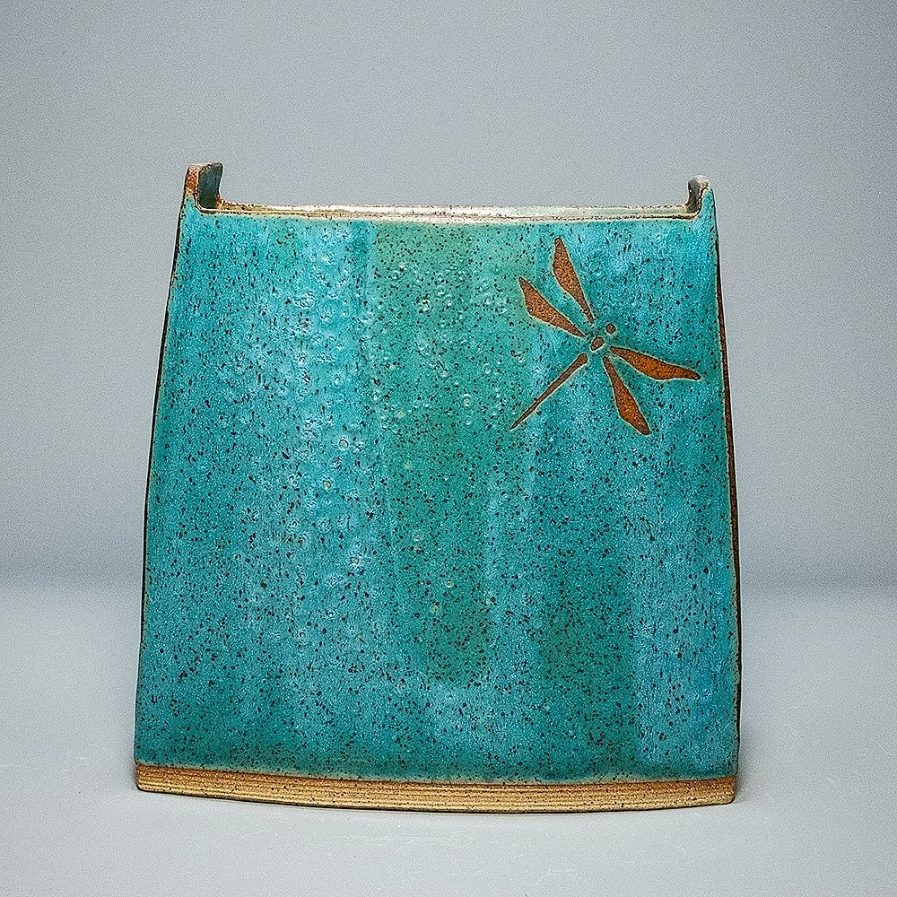 Pocket Vase, 2026. Speckled stoneware, turquoise matte glaze, dragonfly motif. 9"W, 9.5"H, 3.25"D