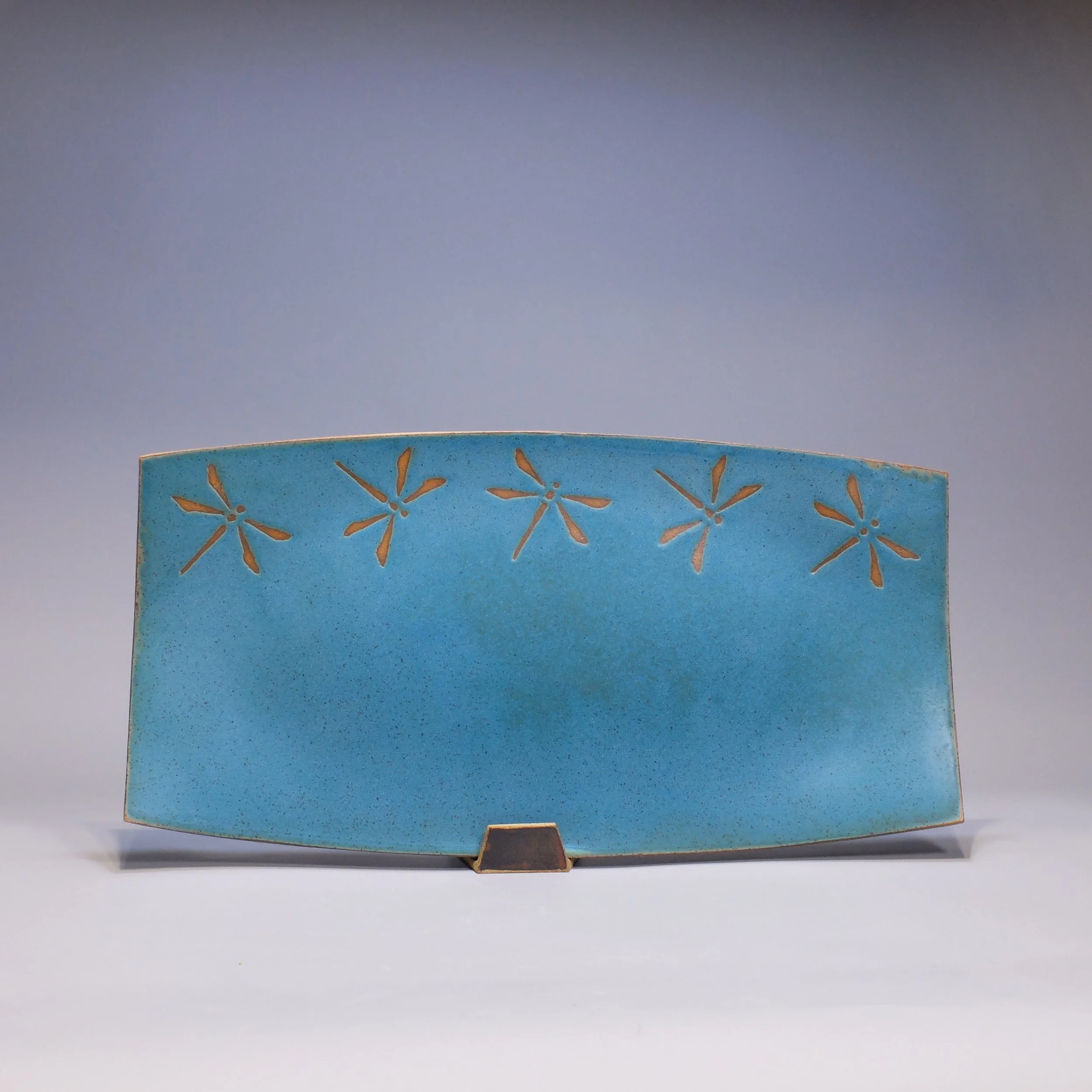 Platter, 2026. Speckled stoneware, turquoise glaze, dragonfly motif. 17.25"L, 8.75"W, 0.75"D.