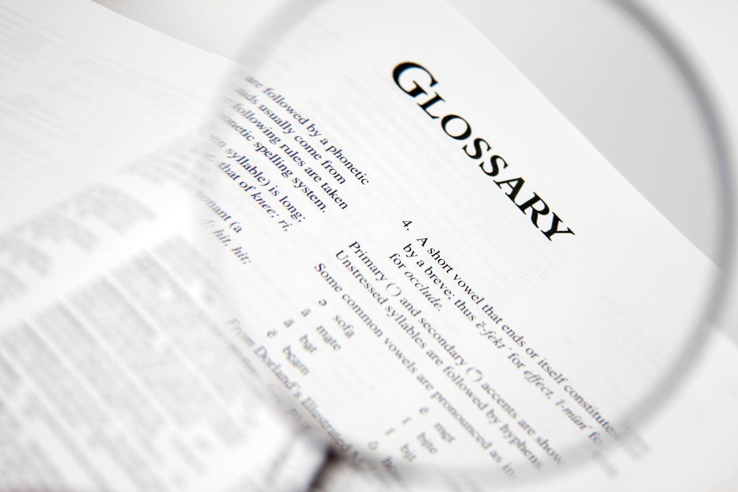Open book and reading glasses on bright workspace representing the real estate buyer glossary created by Gillian Gooch Properties to help Georgia and Florida clients understand key homebuying terms.