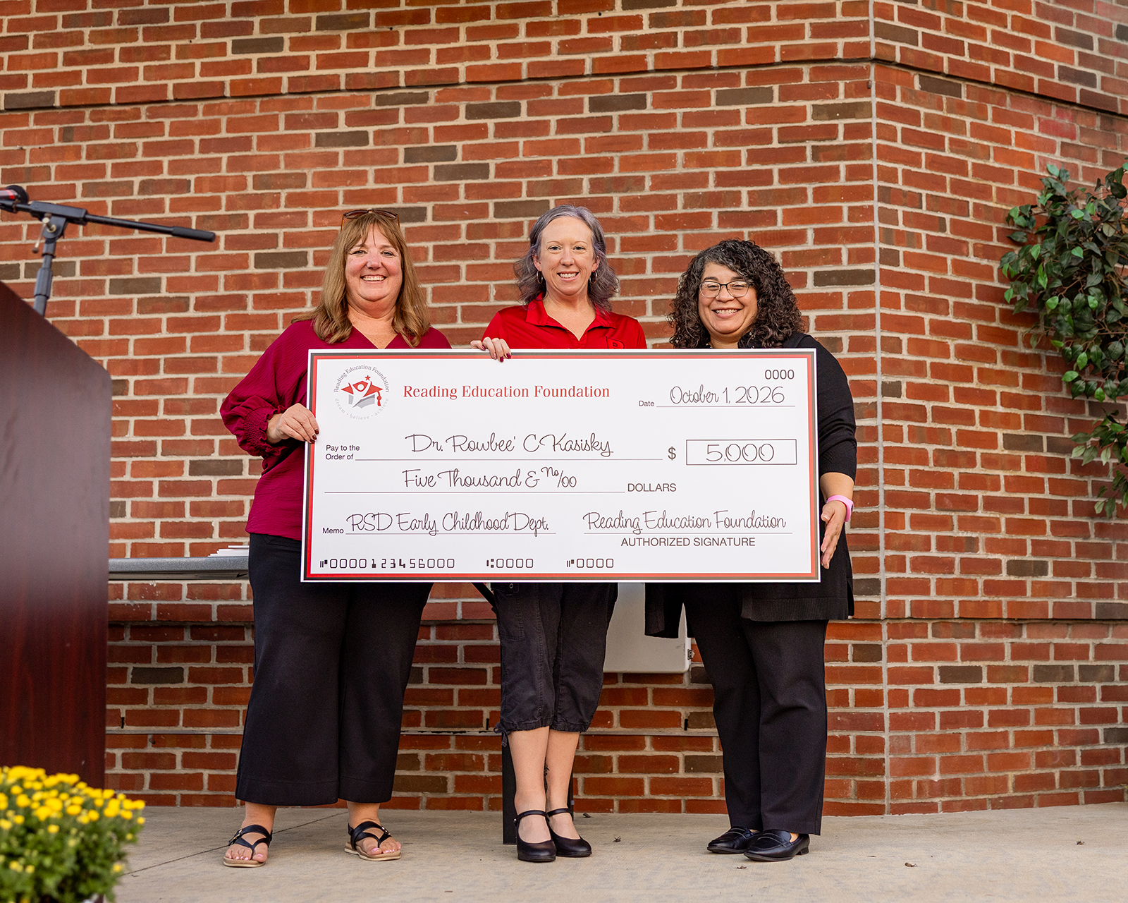 Rowbee’ C. Kasisky holding a large check from Reading Education Foundation