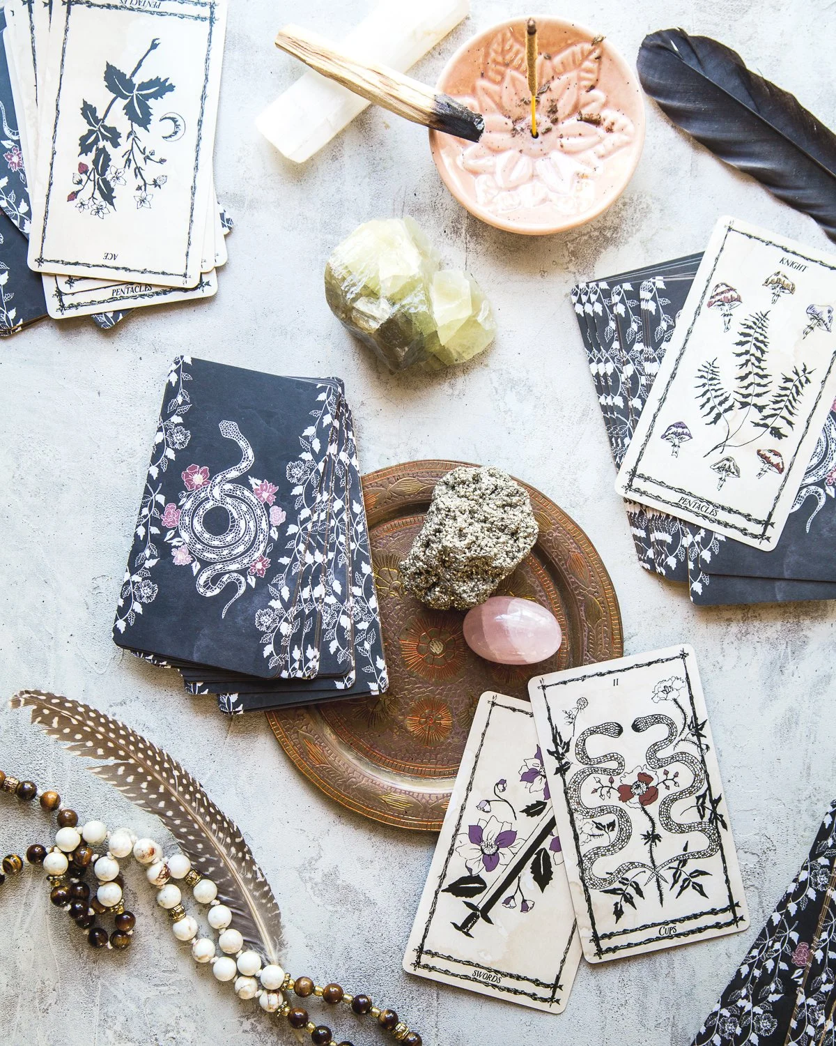 A tarot card reading setup with tarot cards, crystals, and decorative items on a flat surface.
