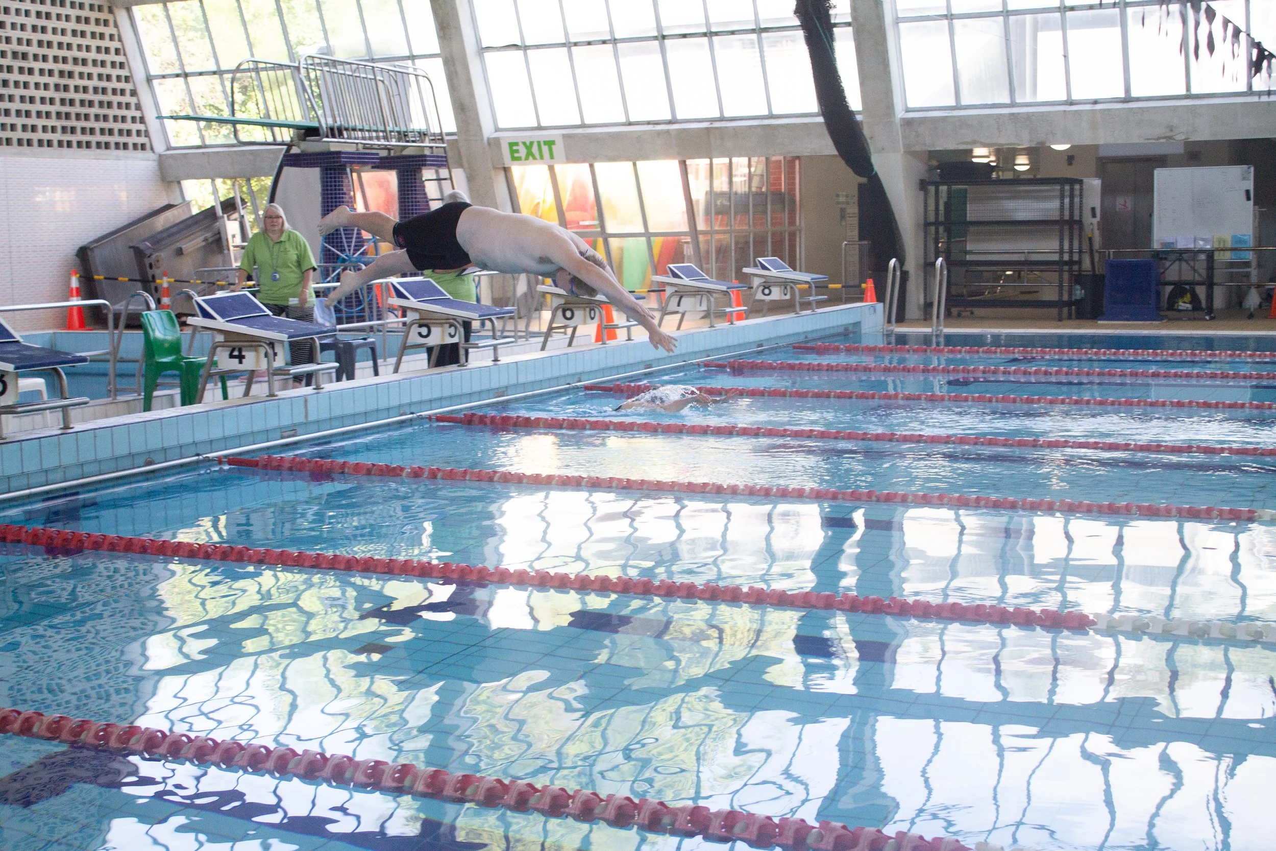 Atheletes diving into the swimming pool at Moana Pool in Dunedin during a race for the Regional Summer games