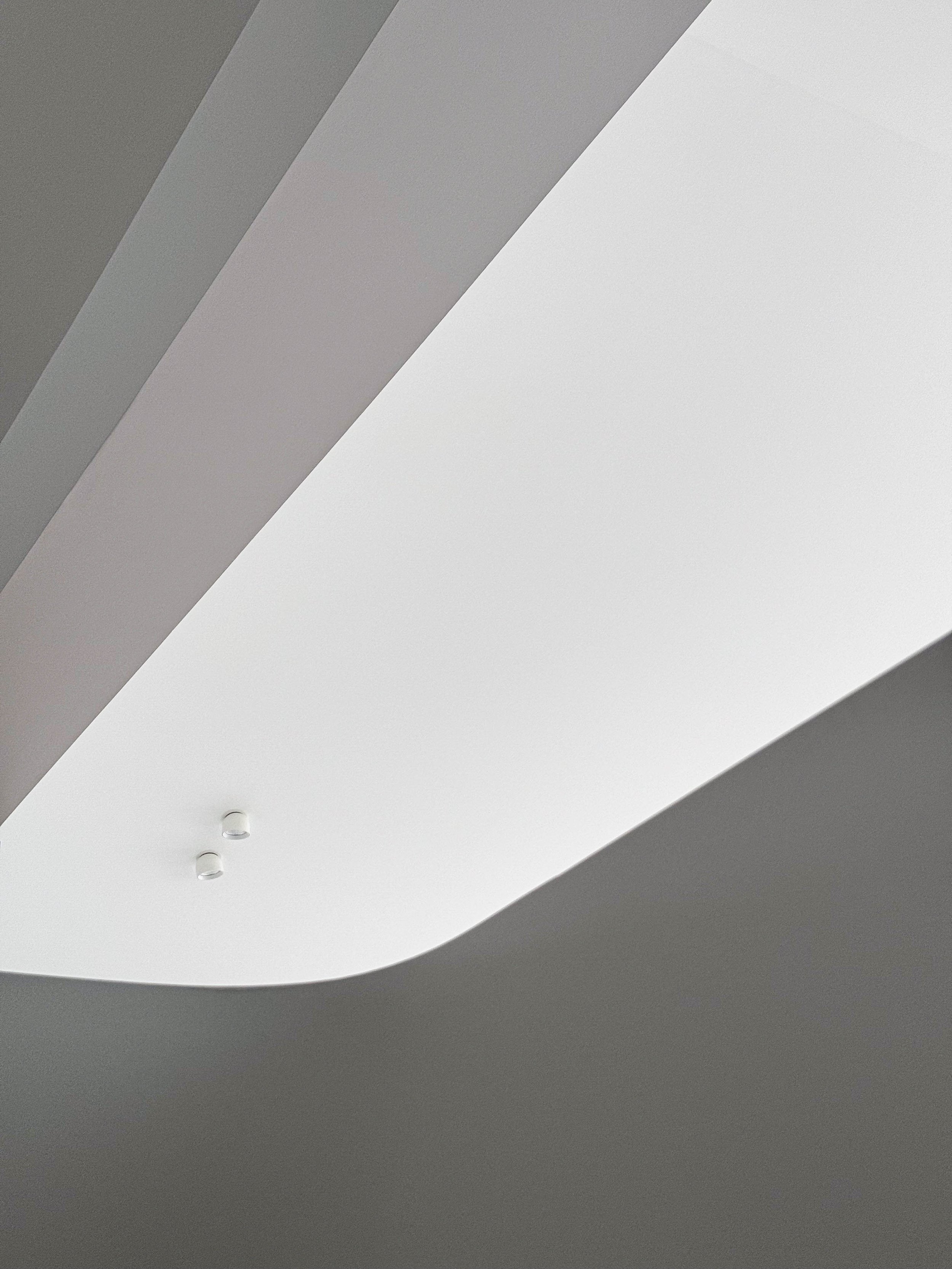 Ceci est une image d'un plafond moderne avec une lumière intégrée encastrée et des murs gris.