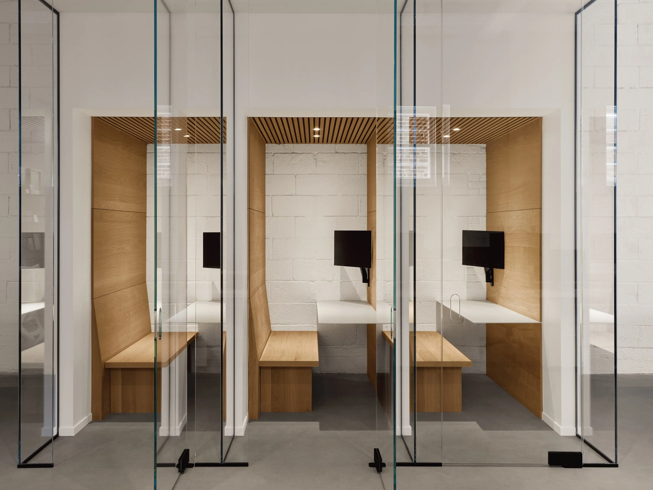 Capsules individuelles avec bureau et écran d'ordinateur dans un espace de travail moderne