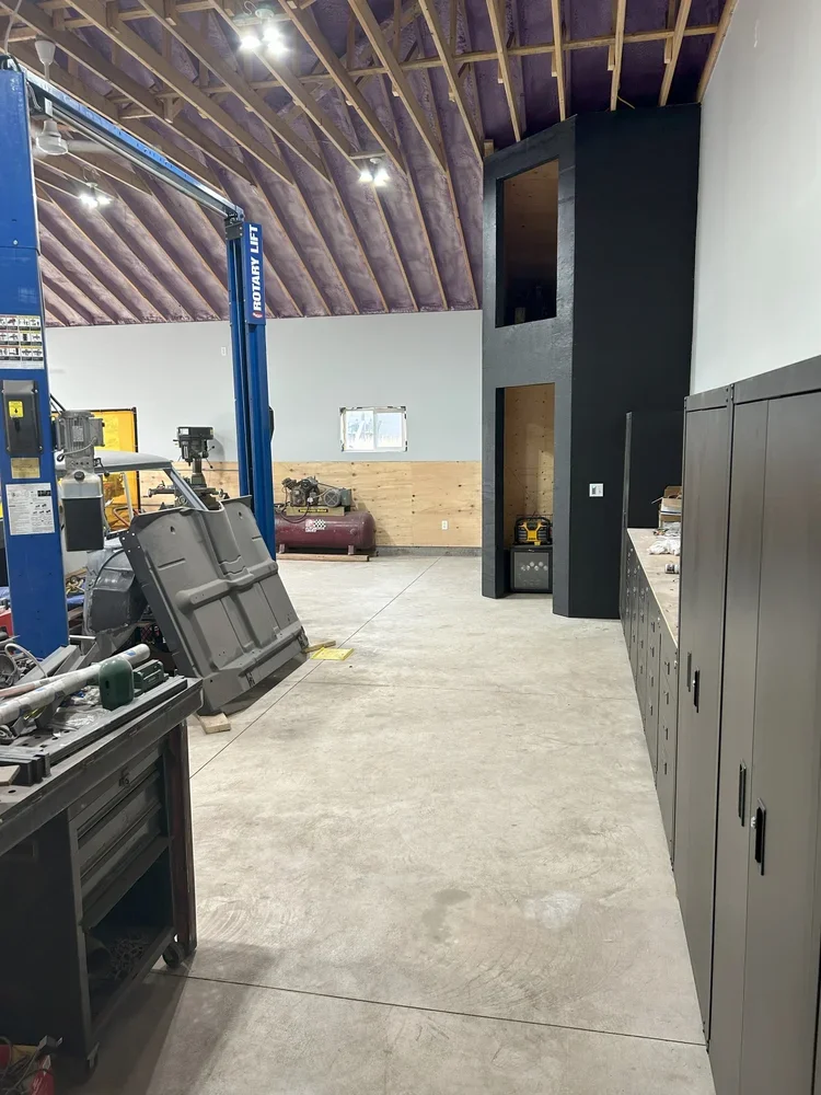 new garage with white painted walls and black cabinets