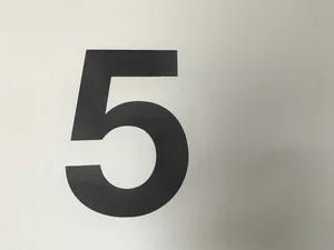 Black number five painted on a white wall.