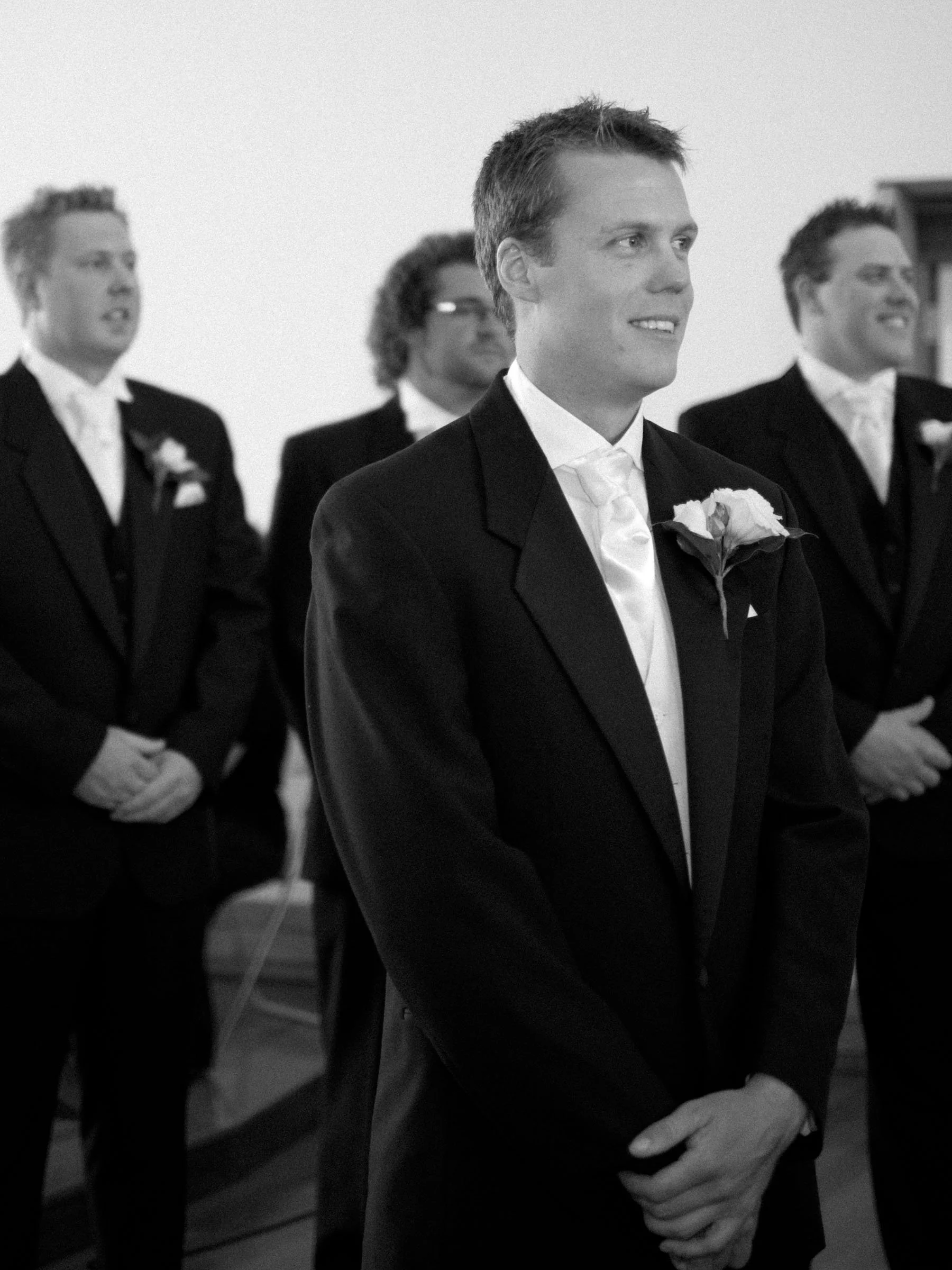 Groom Justin smiling as bride Naomi approaches during HMAS Watson Chapel processional