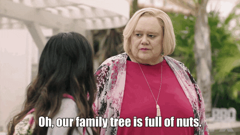 Two women are having a conversation outdoors, with one woman expressing that their family tree is full of nuts.