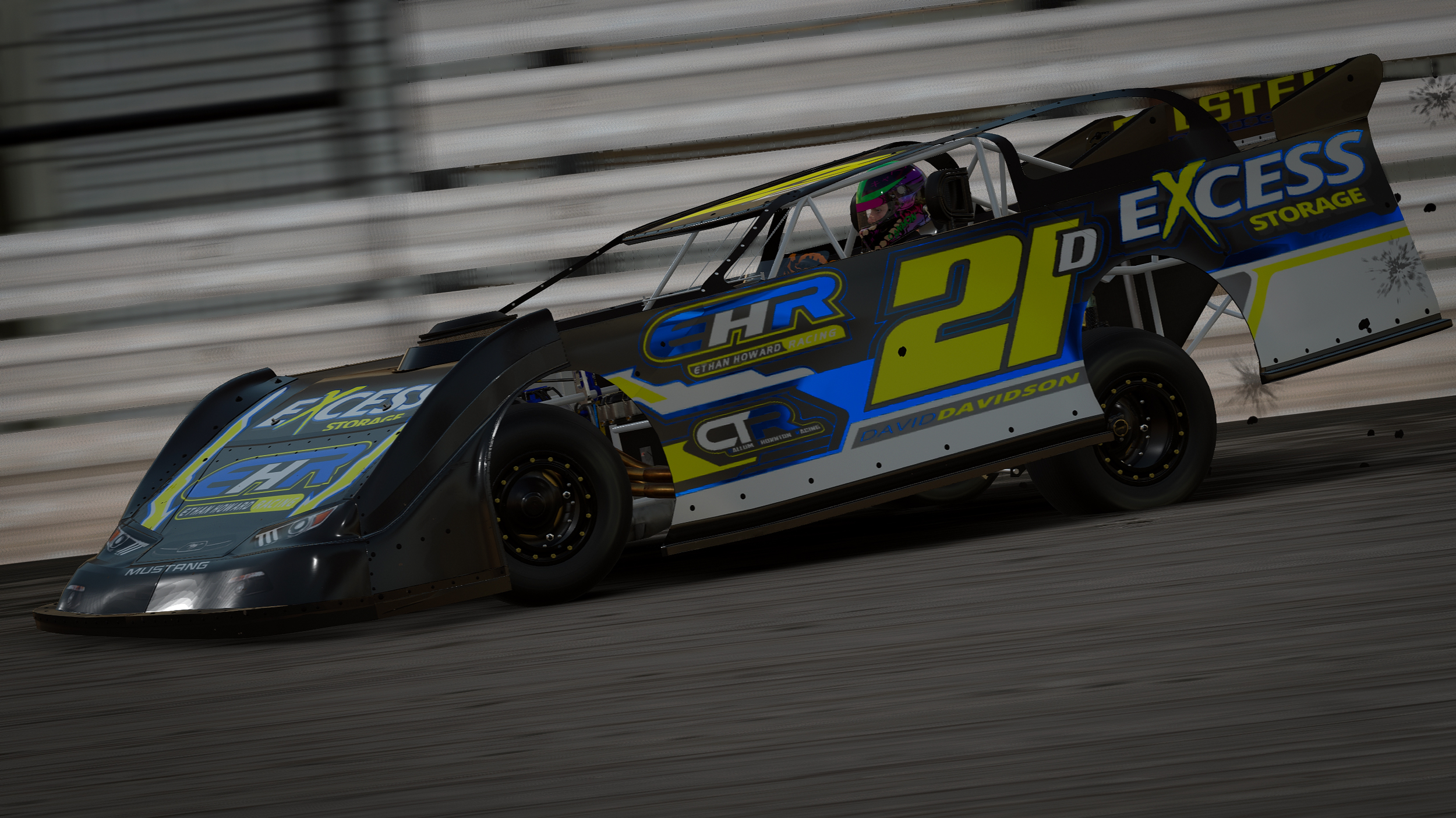 Race car with blue, yellow, and black sponsor logos on a racetrack, with a driver wearing a purple helmet, captured in motion.