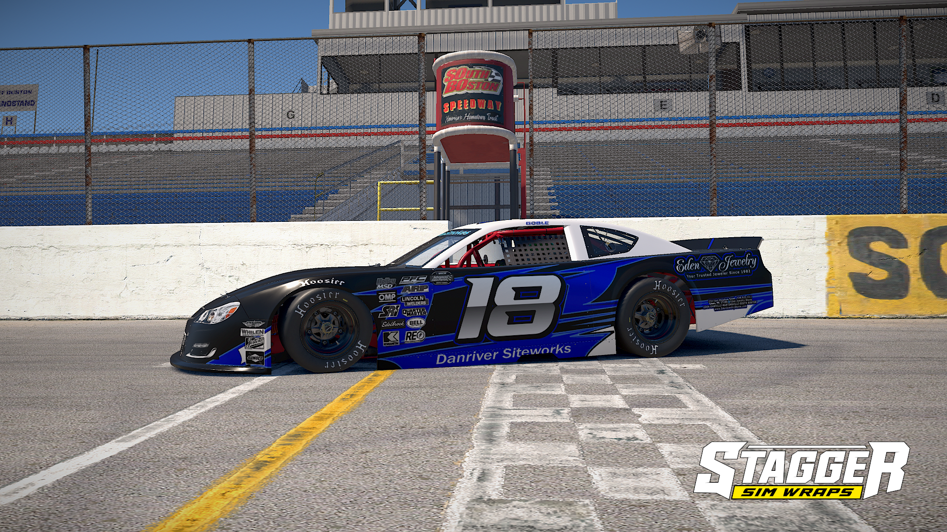 Race car number 18 at South Boston Speedway pit lane, with the track's grandstands and signage in the background.