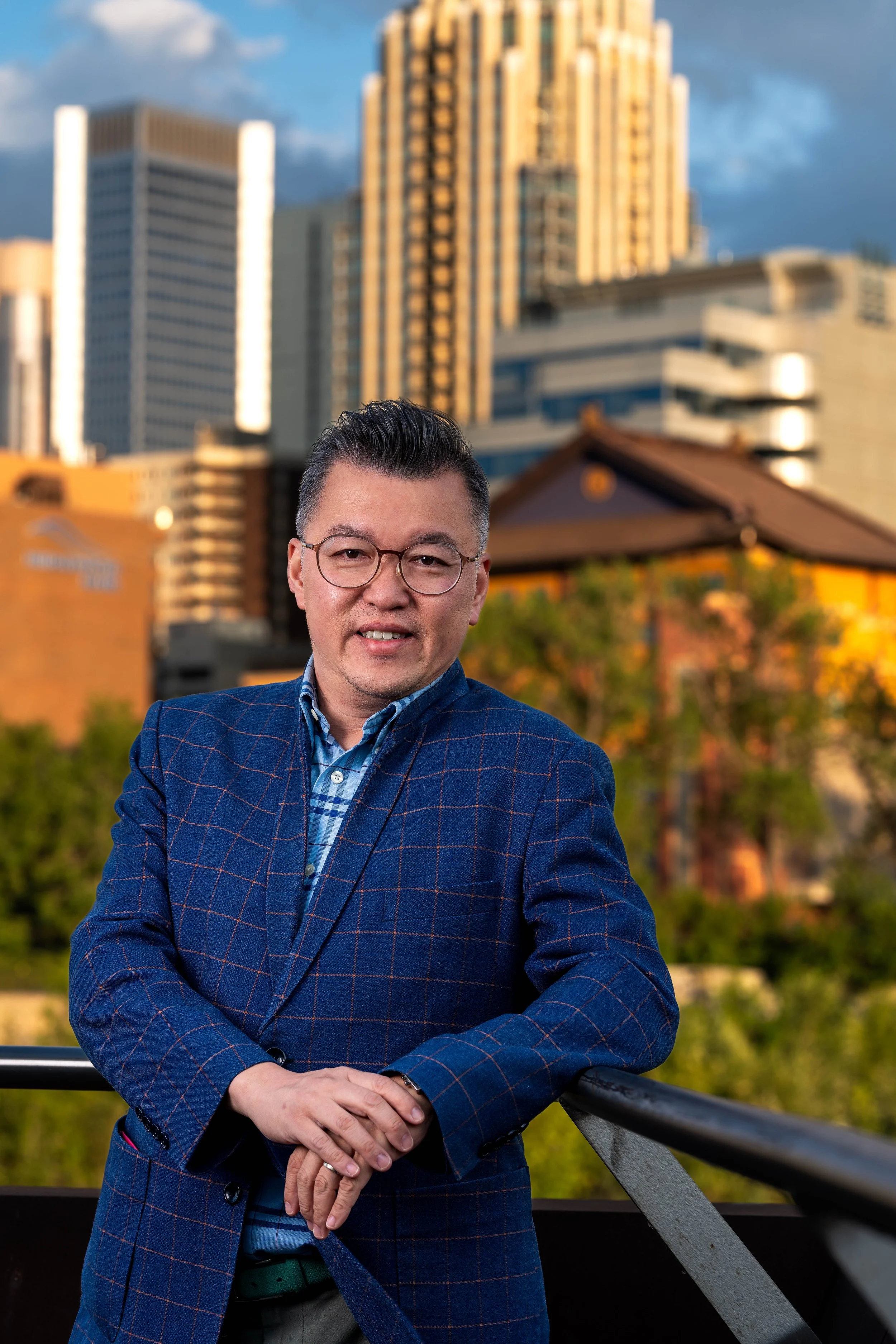 Professional personal brand portrait of a man in front of the Calgary skyline during golden hour.