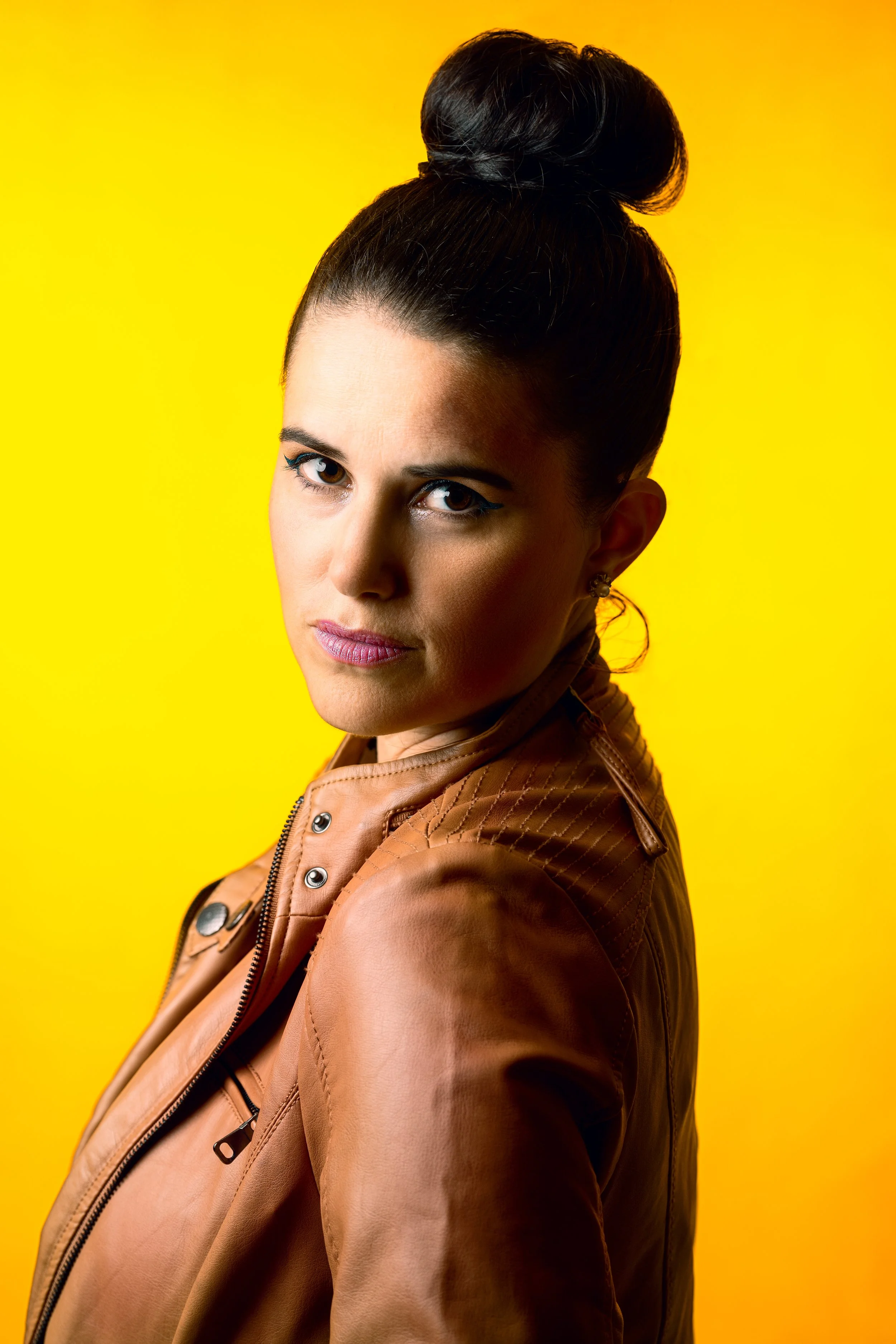 editorial style studio portrait of woman against vibrant yellow backdrop – Calgary fashion photography
