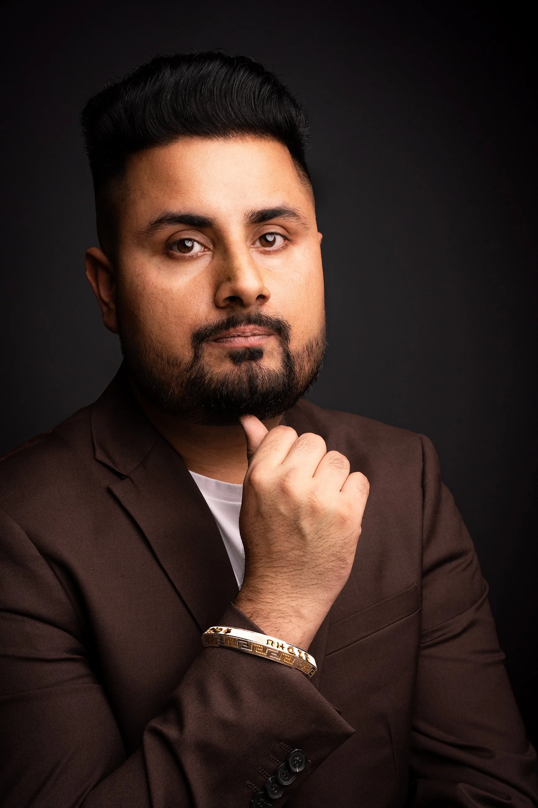 Professional headshot portrait with dramatic studio lighting, photographed for a personal brand or business profile.