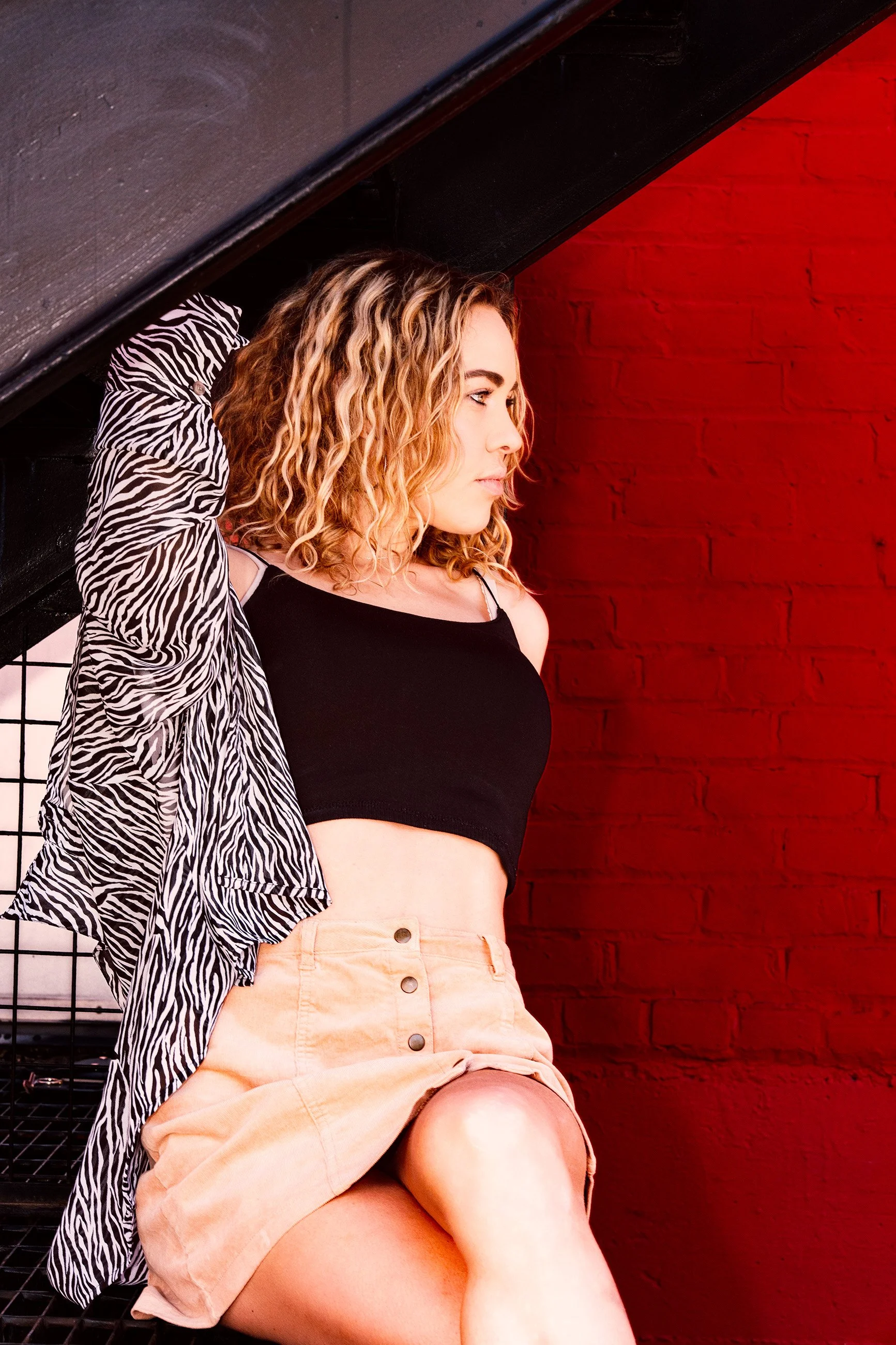 editorial fashion portrait against red brick wall with dramatic color – Calgary photography