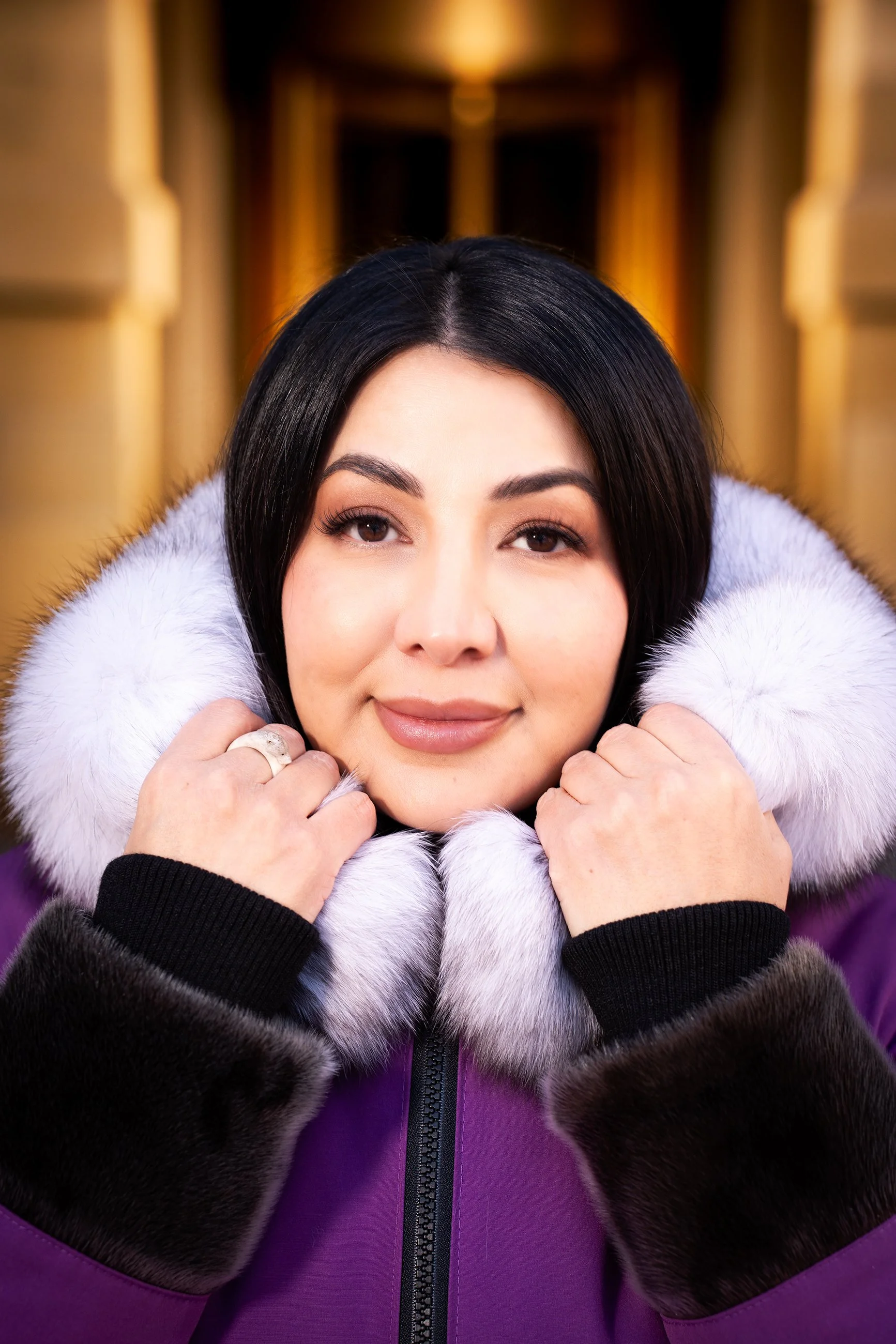 Editorial portrait photography in Calgary featuring a woman in a purple coat, with symmetrical composition and shallow depth of field