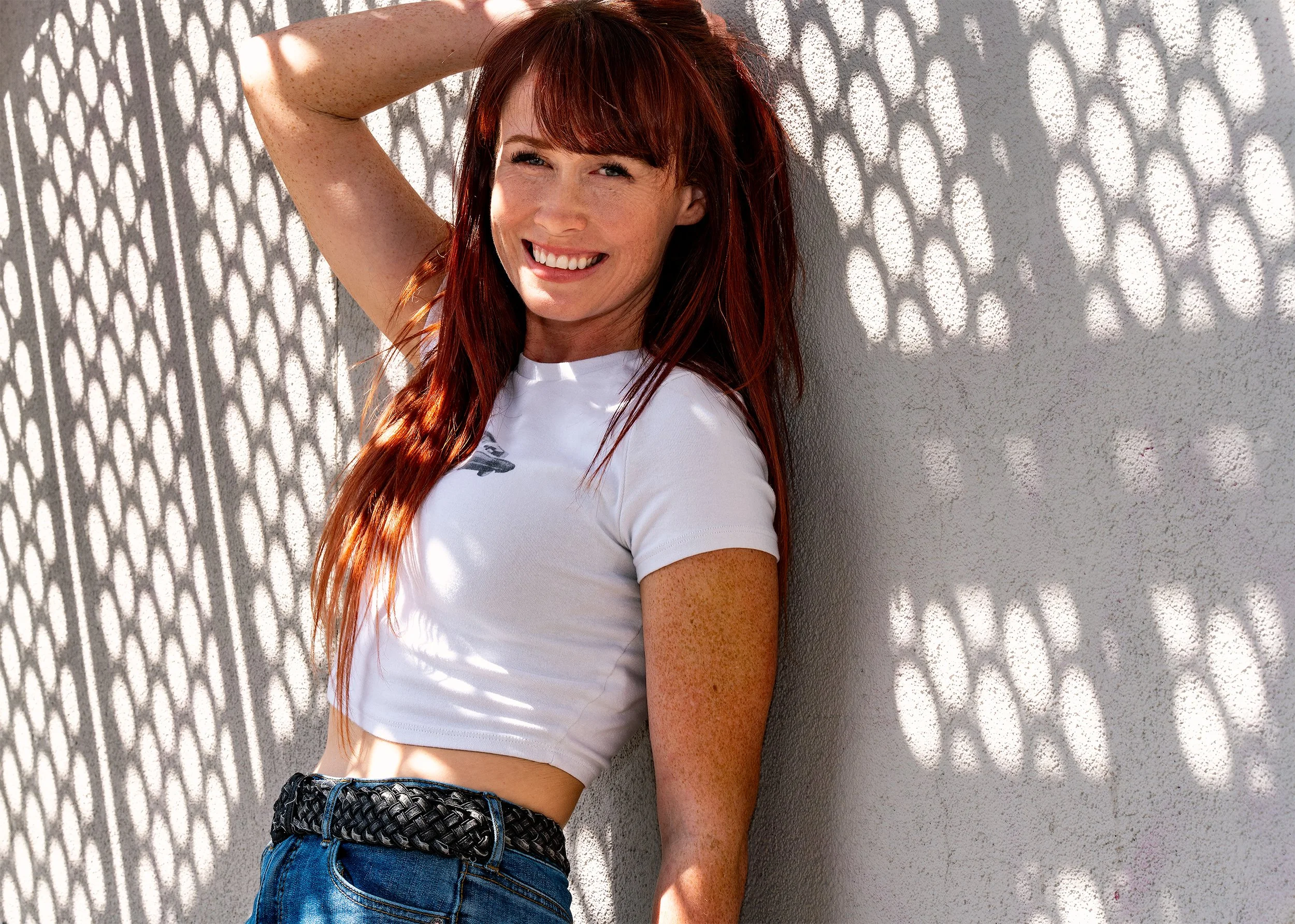 editorial outdoor portrait with patterned sunlight and urban wall – Calgary portrait photography