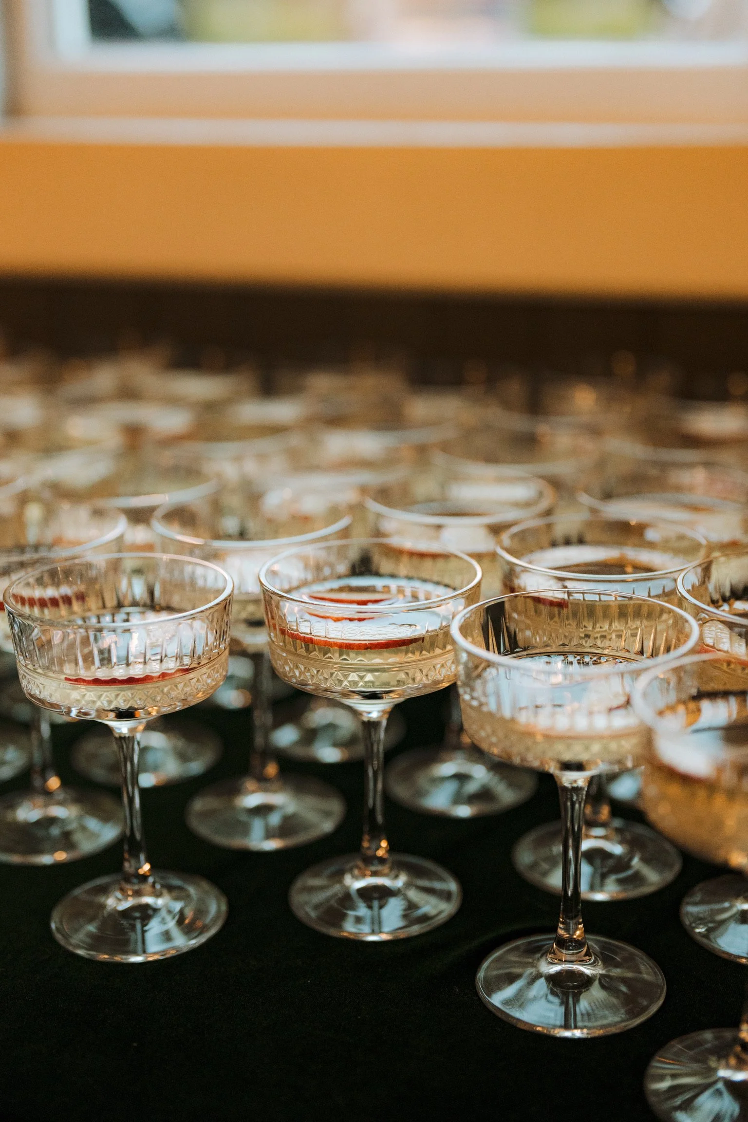Multiple empty cocktail glasses with a textured pattern on a black surface