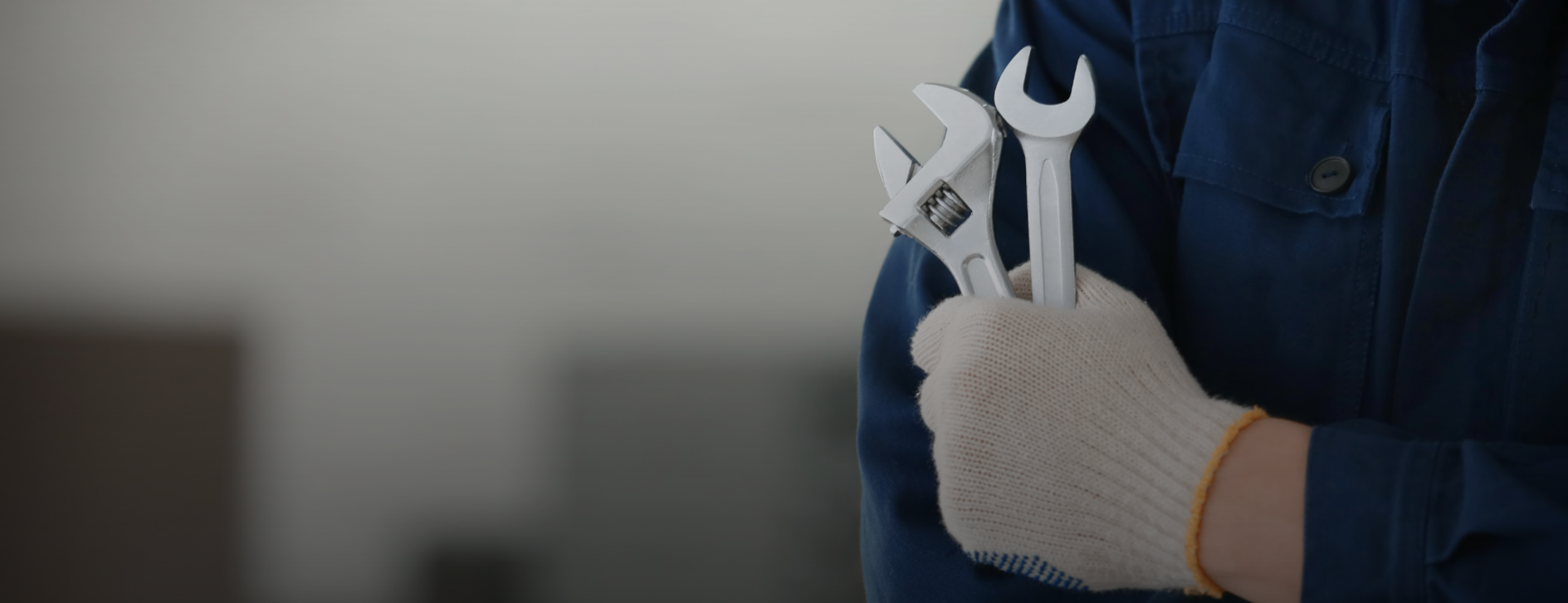 Mechanical technician holding wrench and adjustable spanner tools