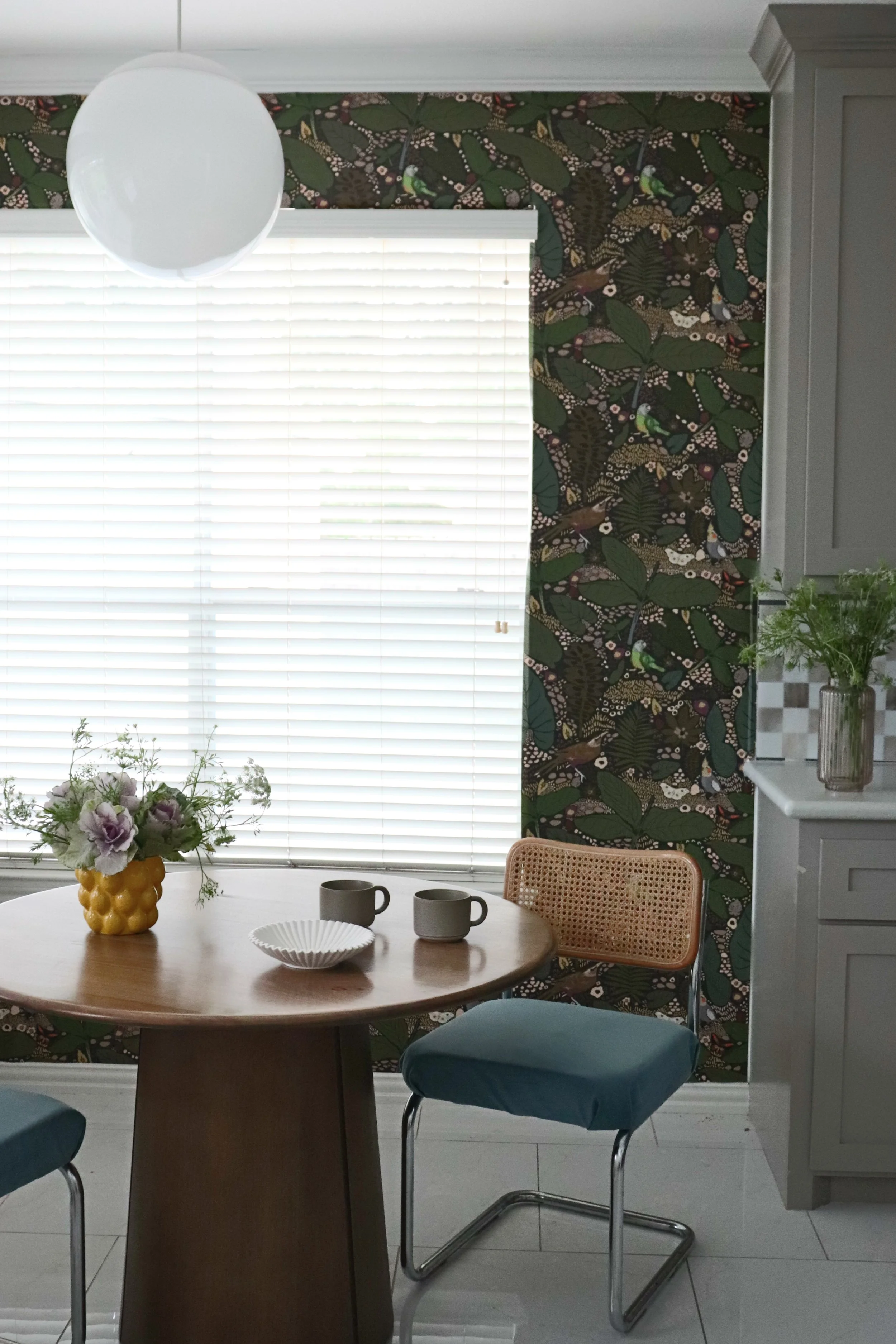 Matiz project breakfast nook featuring custom upholstered cantilever chairs and botanical wallpaper in a family-friendly residential design.