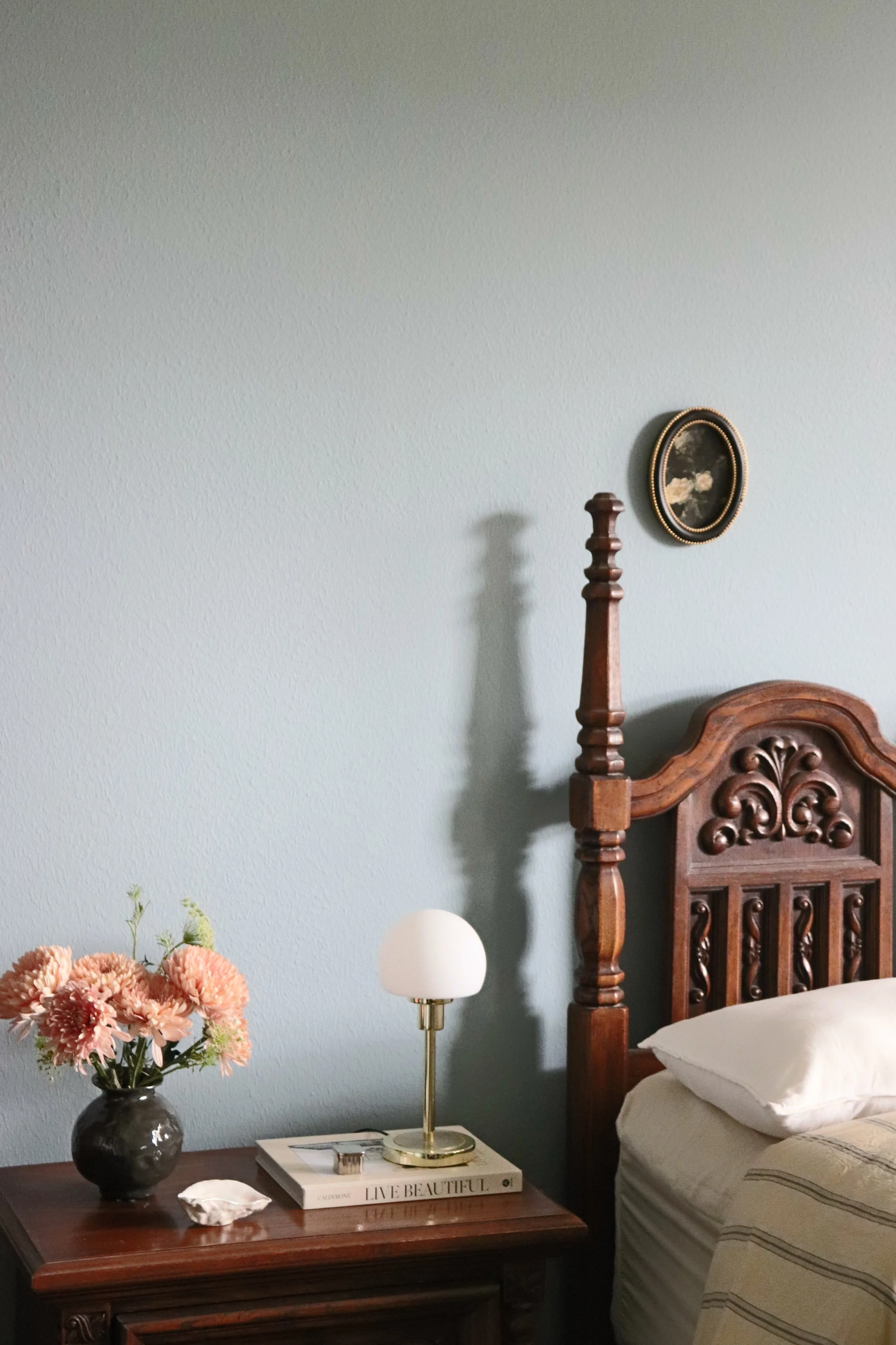 Matiz primary bedroom featuring a meditative blue color palette, mid-century furniture, and modern bedside lamp lighting.
