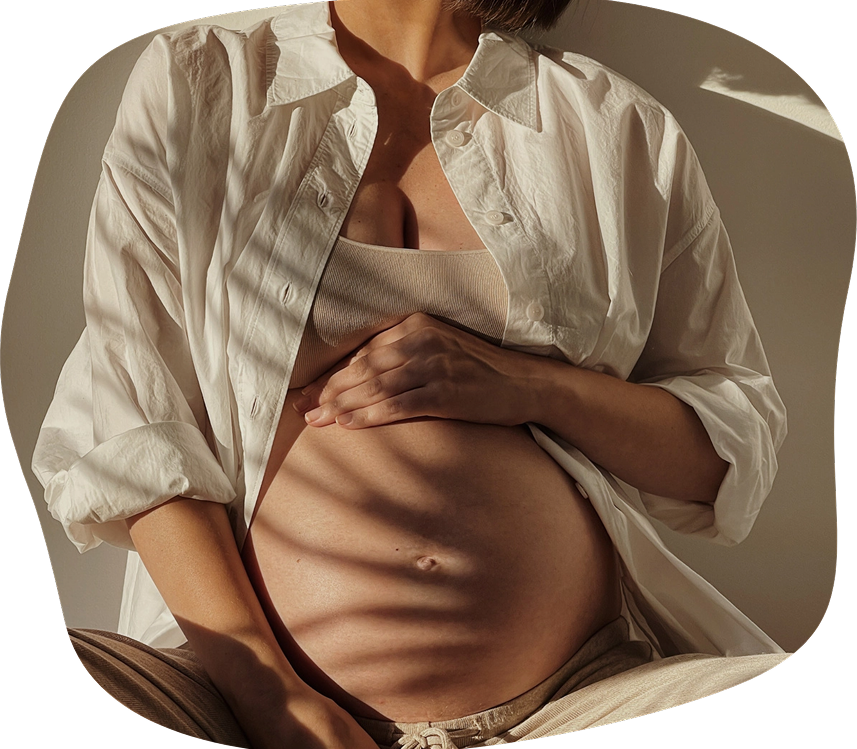 A woman wearing a white shirt and beige tube top, lifting her shirt to reveal her bare abdomen, with lighting creating shadows.