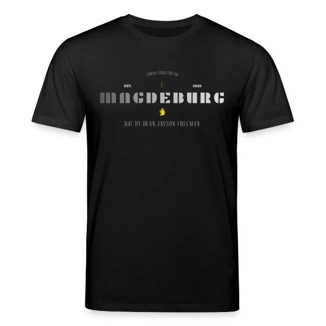 Schwarzes T-Shirt mit Text und Grafiken, mit der Aufschrift 'Magedberg', 'EST. 2025', 'DIE BY DEAN JAYSON FREEMAN' und einem kleinen gelben Kaugummi-Logo in der Mitte.