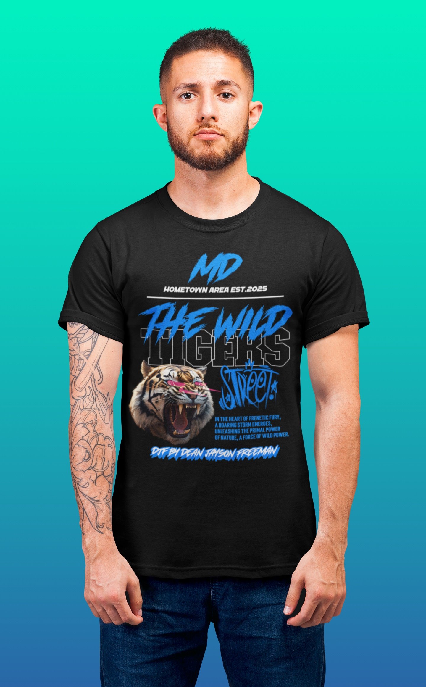 Ein junger Mann mit kurzem Haar und Bart trägt ein schwarzes T-Shirt mit einem Tigermotiv und blauer Schrift. Er steht vor einem bunten, texturierten Hintergrund.