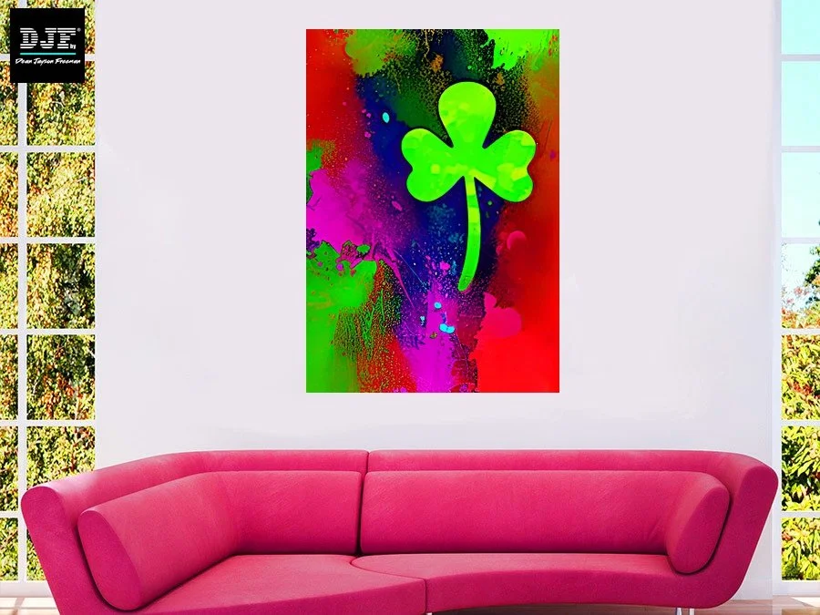 Farbenfrohes Wandbild mit einem grünen Kleeblatt auf einem bunten, abstrakten Hintergrund in einem Wohnzimmer mit pinkem Sofa.