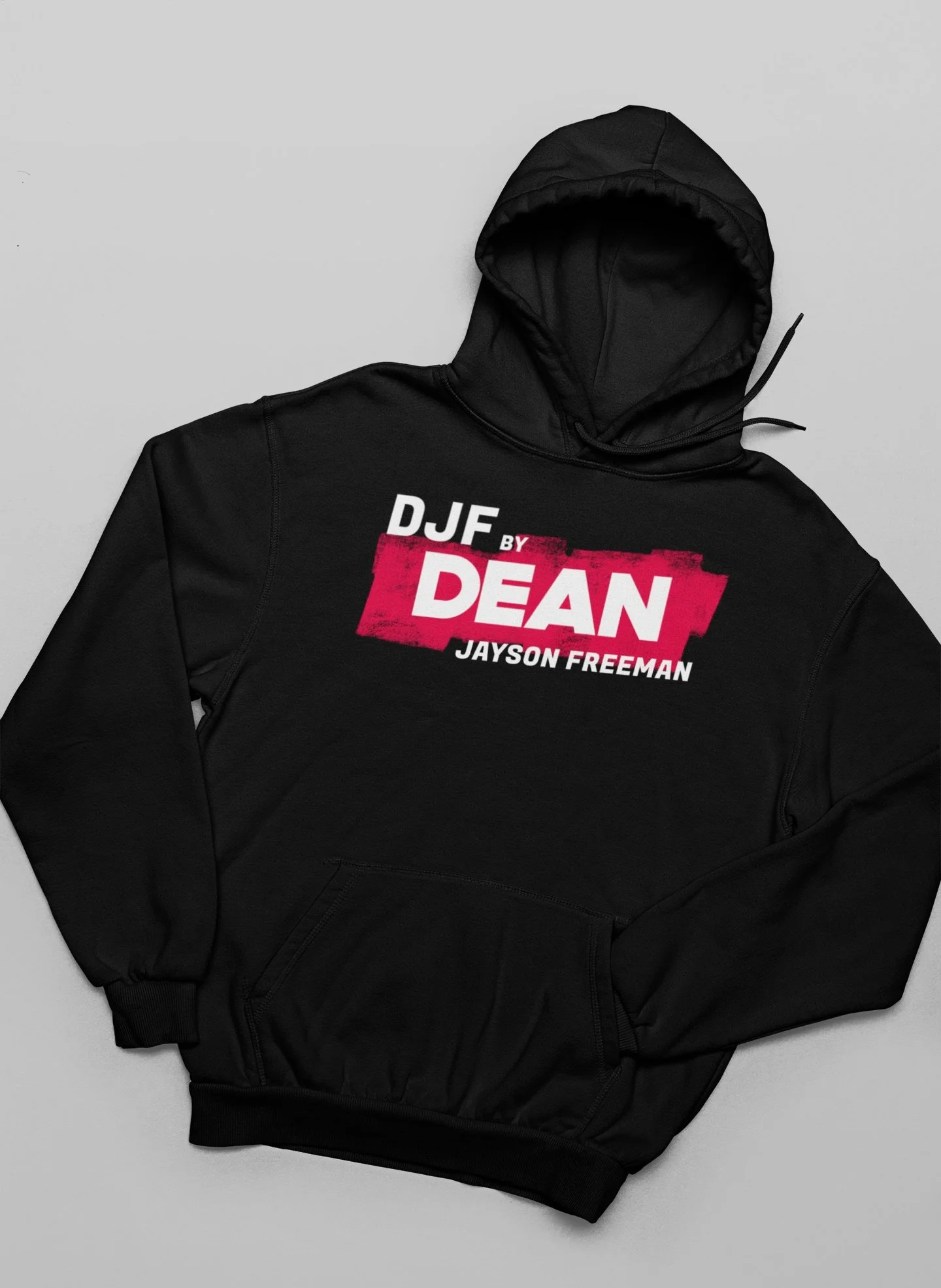 Schwarze Kapuzenjacke mit aufgedrucktem Text "DJF by DEAN JAYSON FREEMAN" auf der Vorderseite, liegt auf einer grauen Oberfläche.
