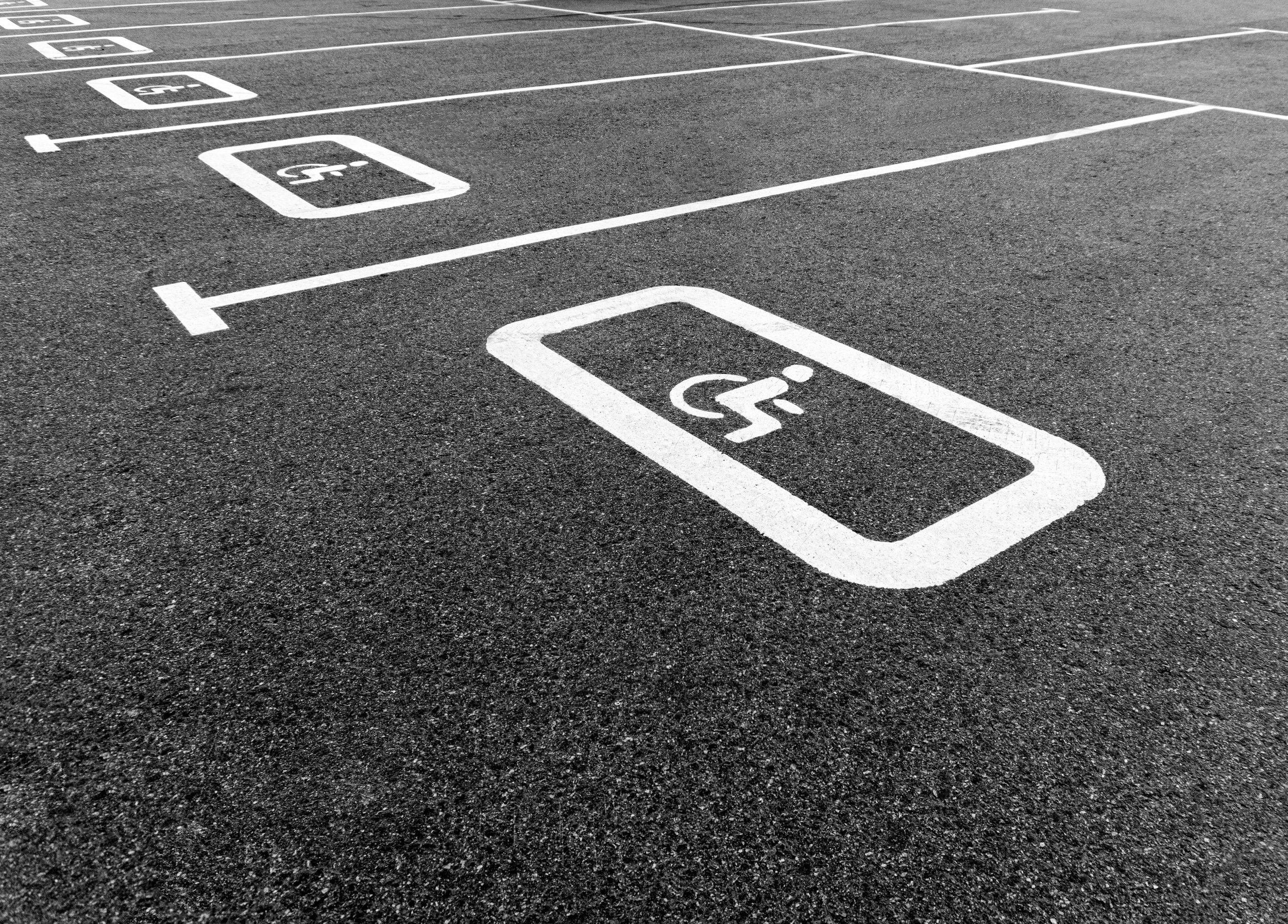 Empty parking lot with designated electric vehicle charging stations marked on asphalt.