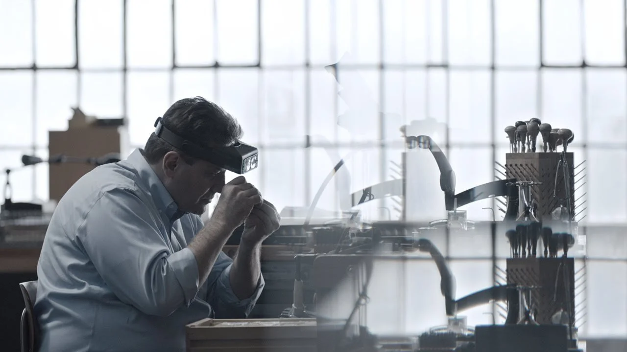 A diamond expert is examining a diamond in his office