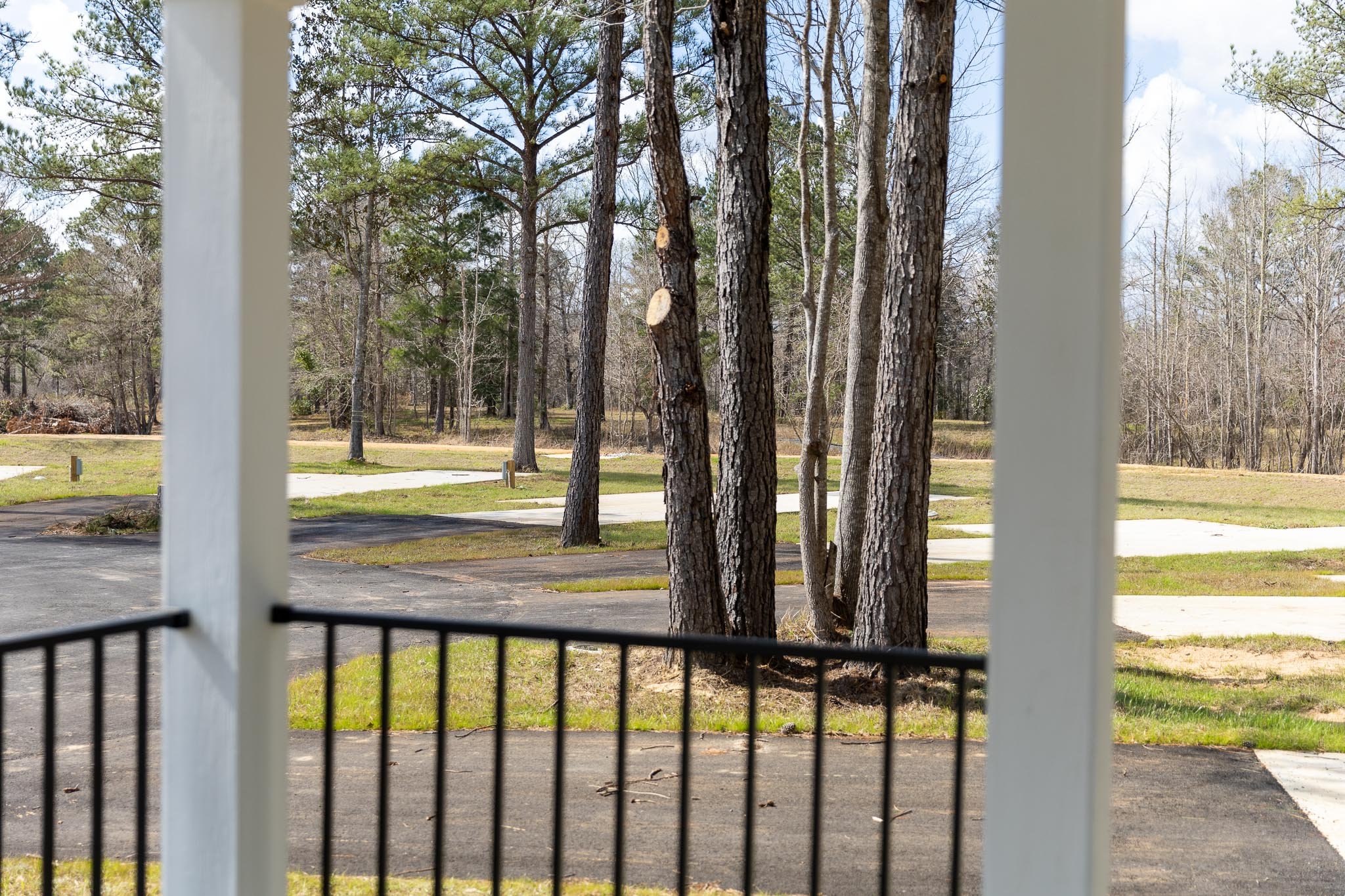 View from a porch overlooking RV sites and tall pine trees at Chumuckla Springs RV Resort in Northwest Florida